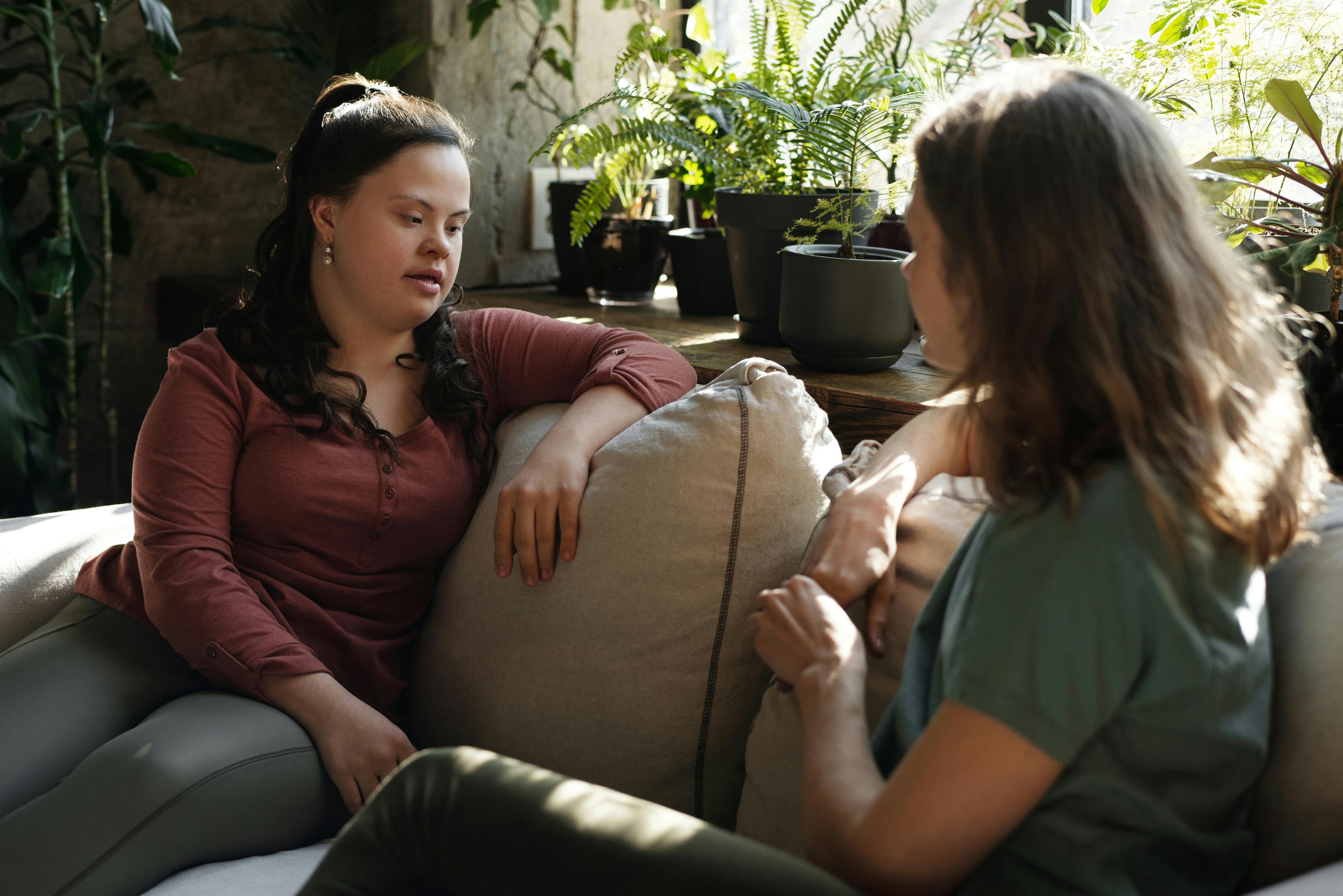 Deux femmes assises sur un canapé en train de parler | Source : Pexels