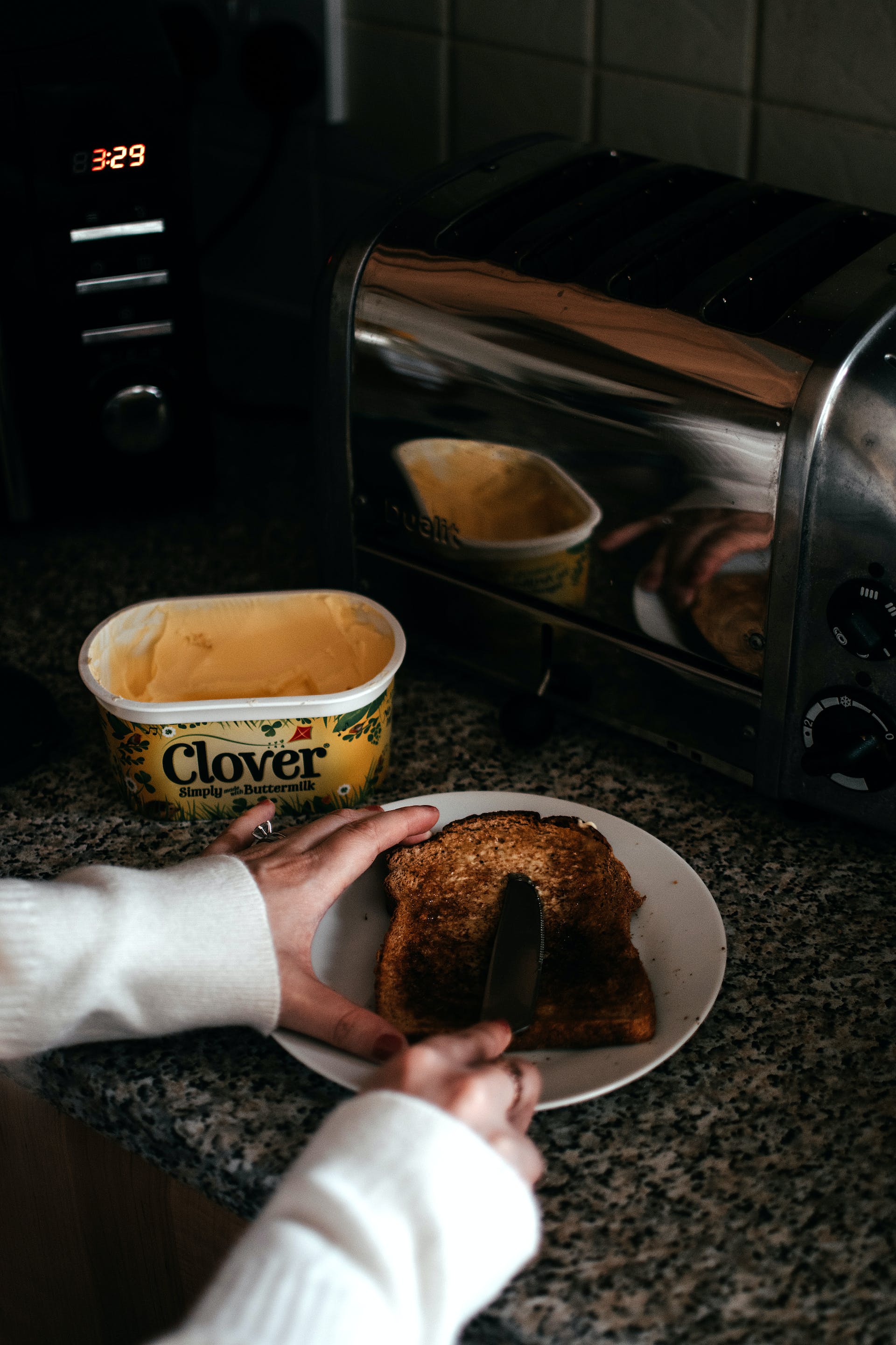 Personne étalant du beurre sur un toast | Source : Pexels