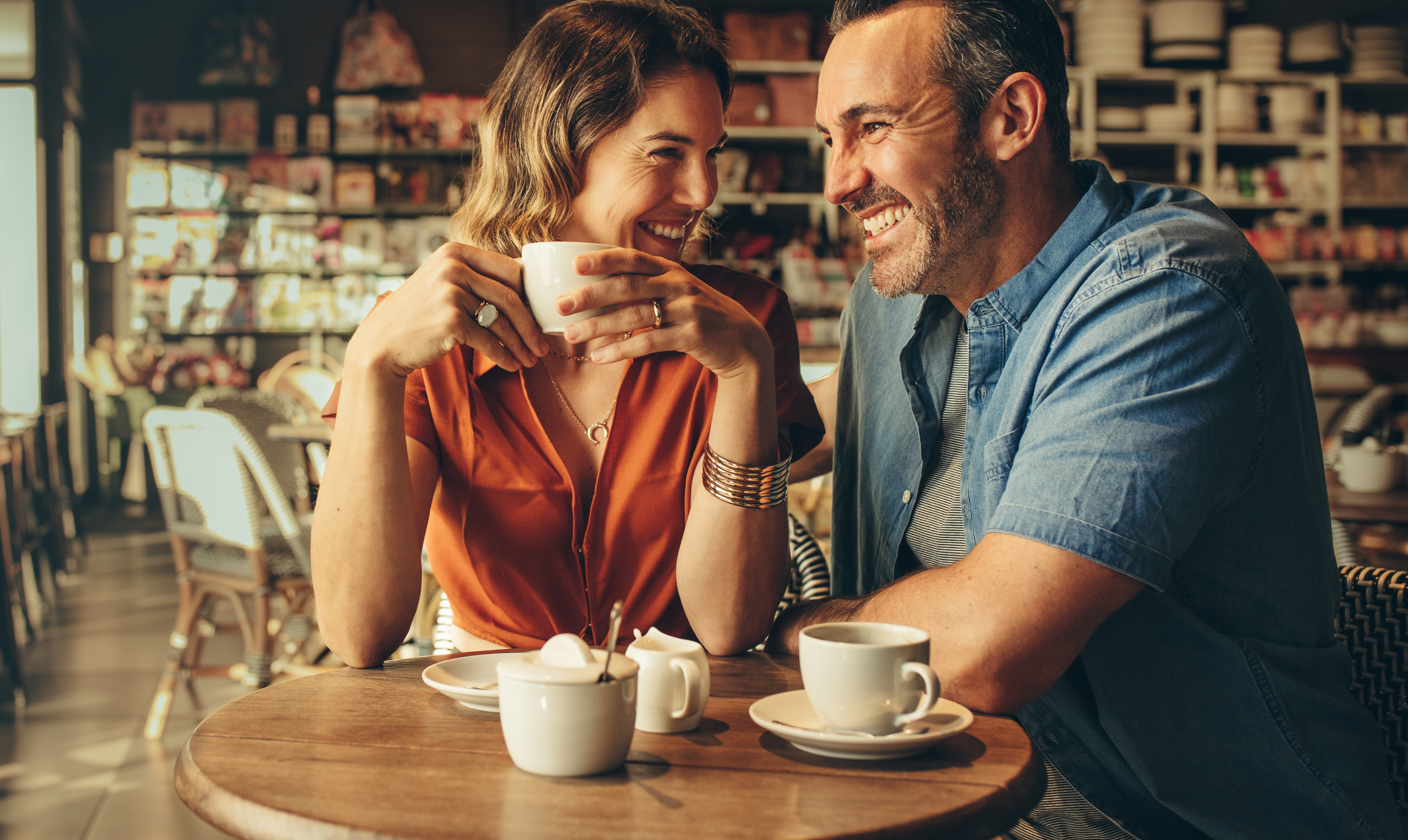 Un couple heureux qui rit autour d'un café | Source : Shutterstock