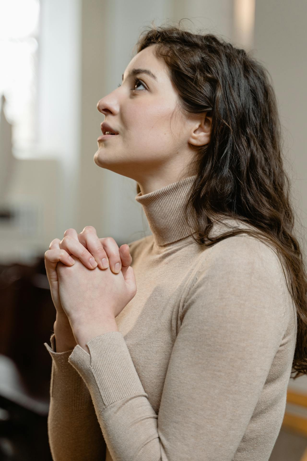 Une jeune femme désespérée dans une église | Source : Pexels