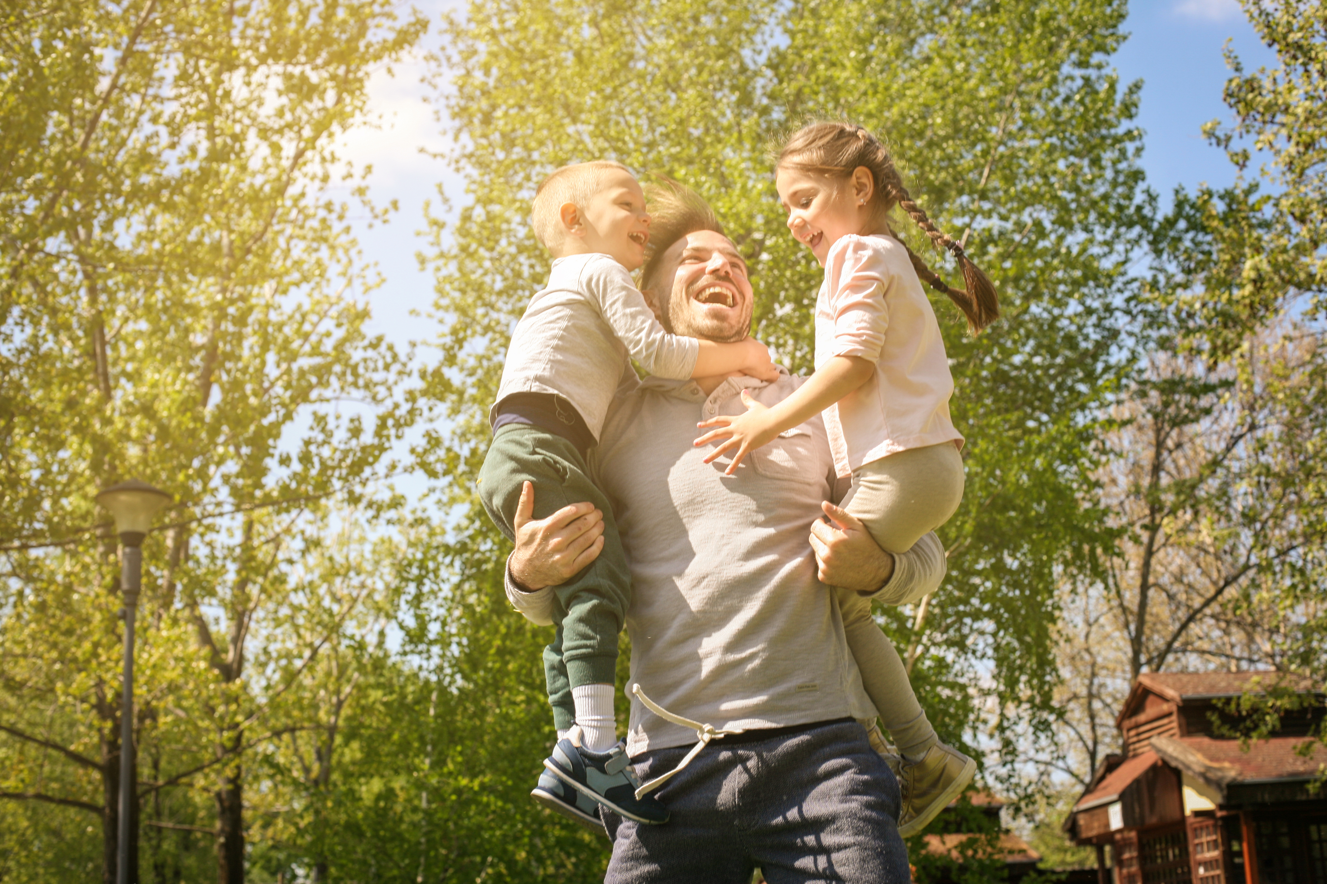 Un père joyeux qui joue avec ses enfants dans le pré | Source : Shutterstock