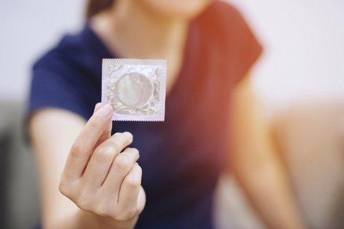 Une femme qui tient un préservatif dans la main | Photo : Shutterstock