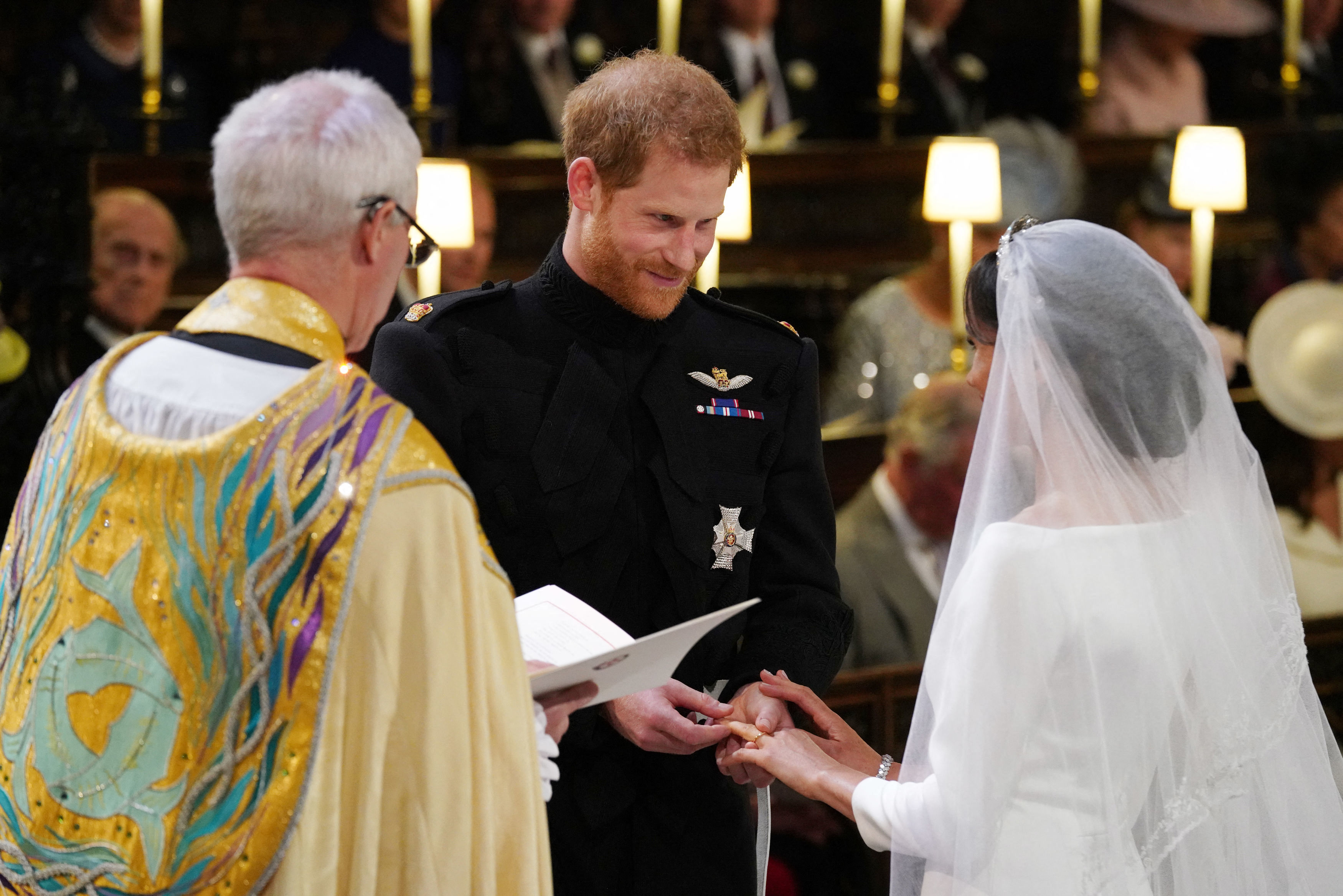 Le prince Harry, duc de Sussex, passe l'alliance au doigt de Meghan Markle lors de leur cérémonie de mariage à la chapelle St George, au château de Windsor, le 19 mai 2018 | Source : Getty Images