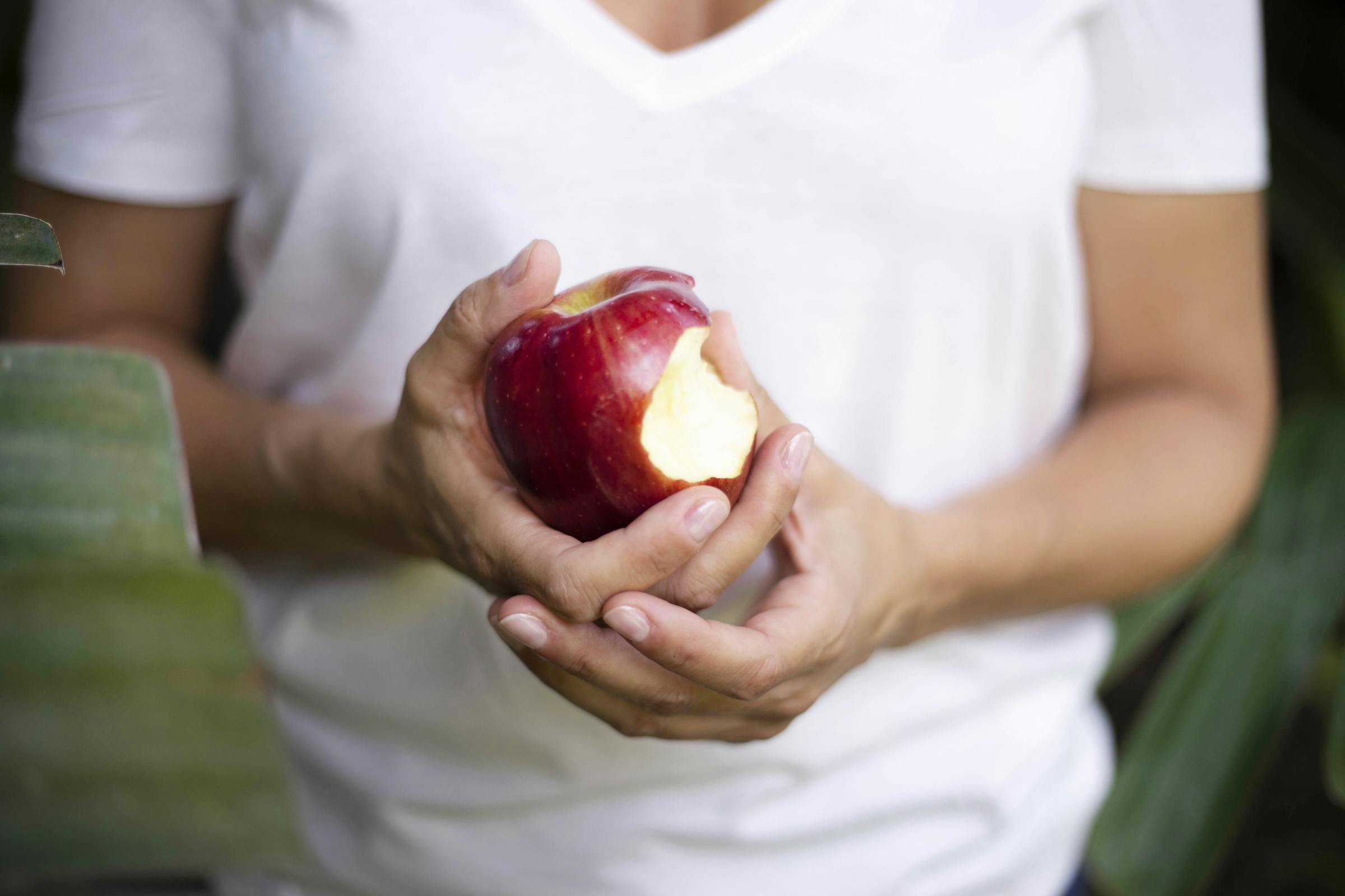 Une femme tenant une pomme croquée | Source : Pexels