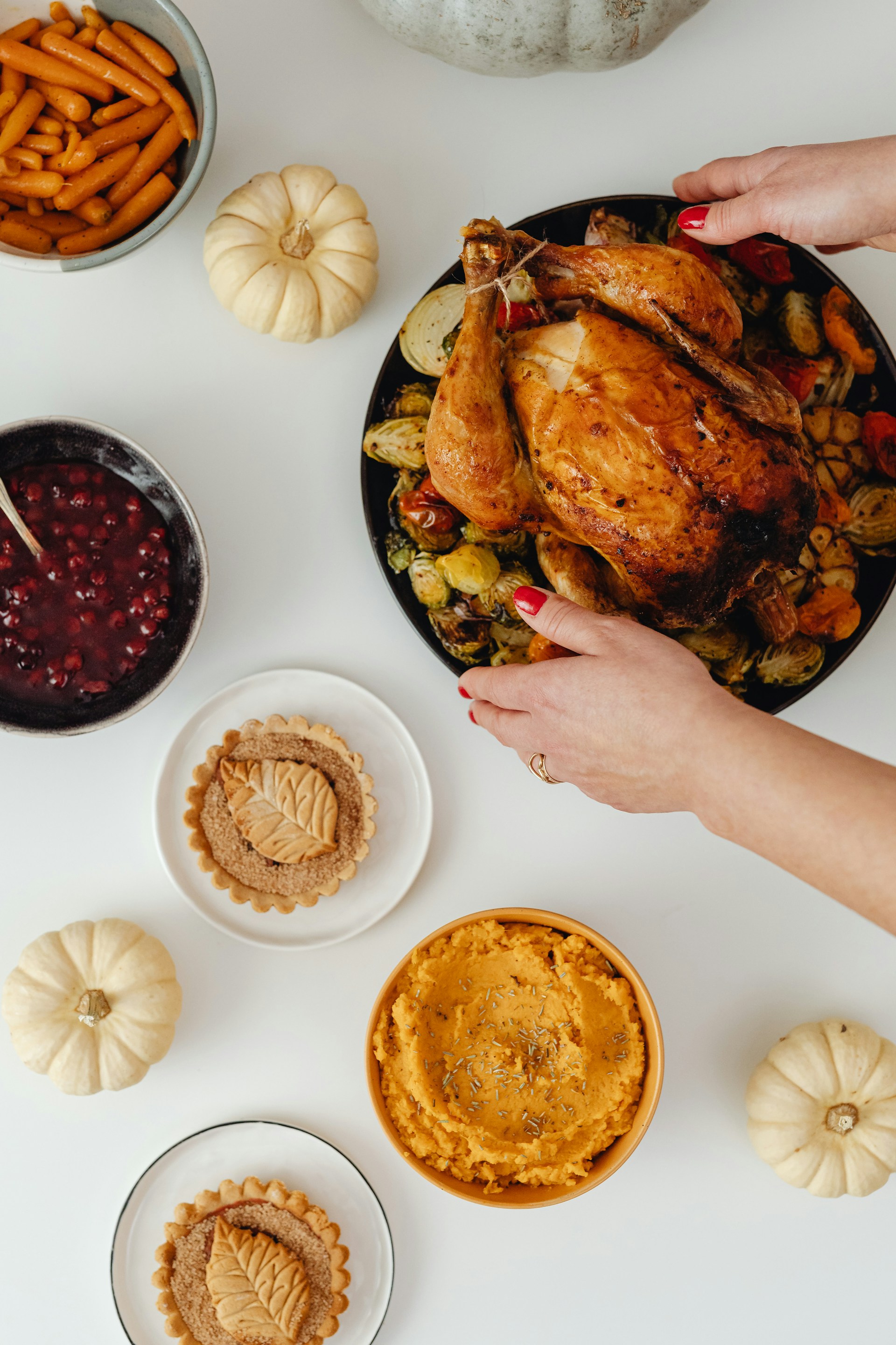 Une femme plaçant une assiette de poulet rôti sur la table | Source : Unsplash