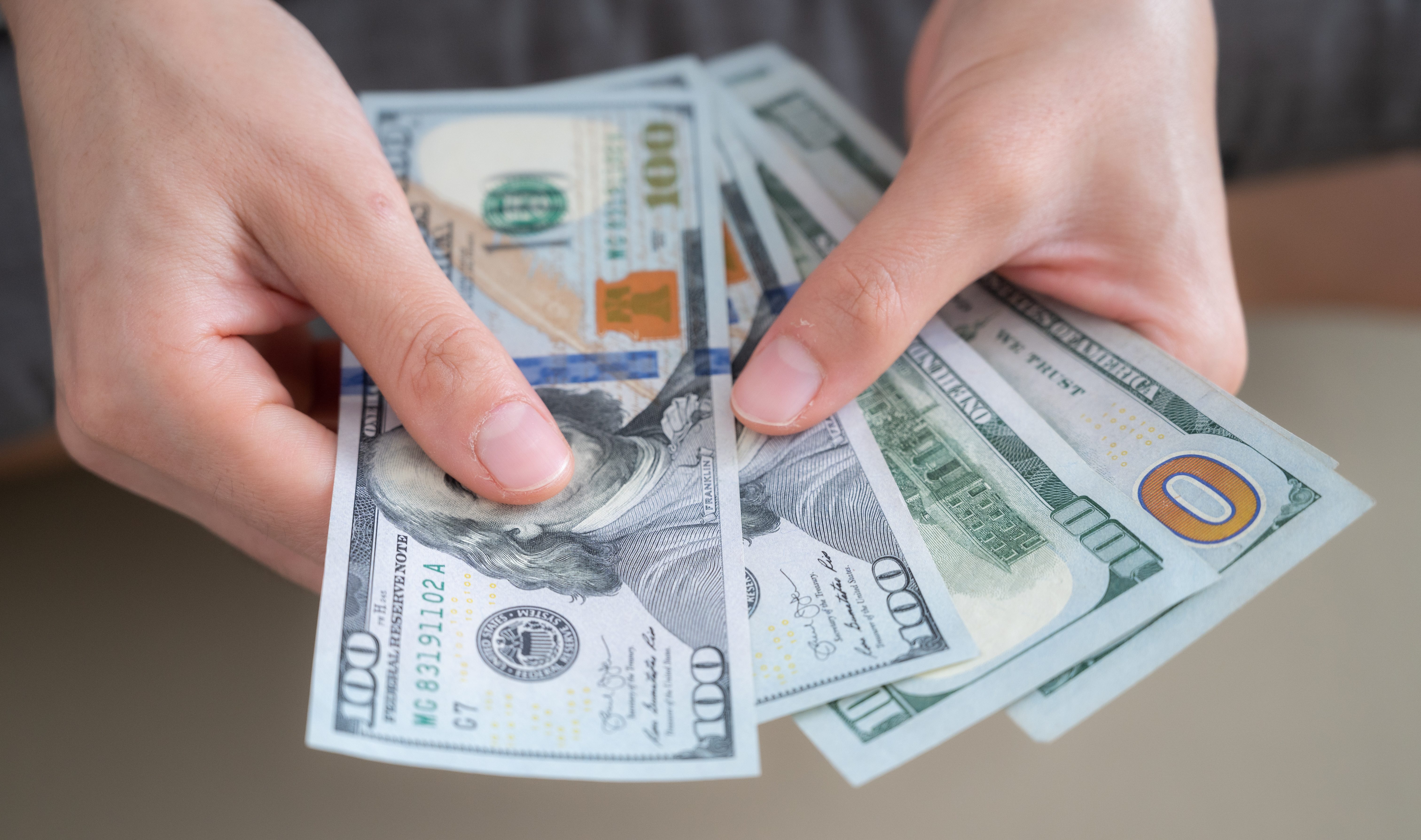 Mains comptant des dollars américains | Source : Getty Images