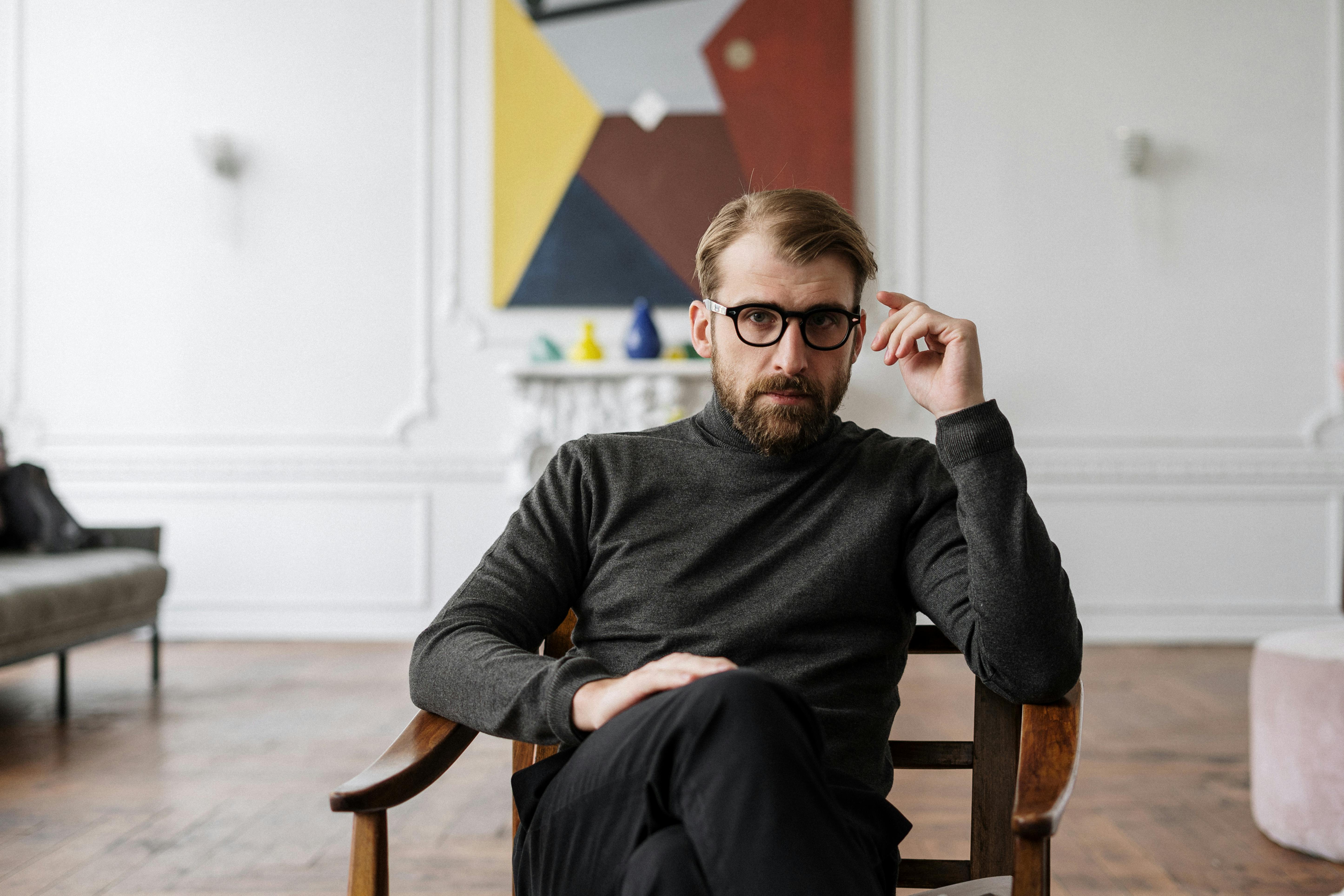 Un homme à l'air sérieux assis sur une chaise | Source : Pexels