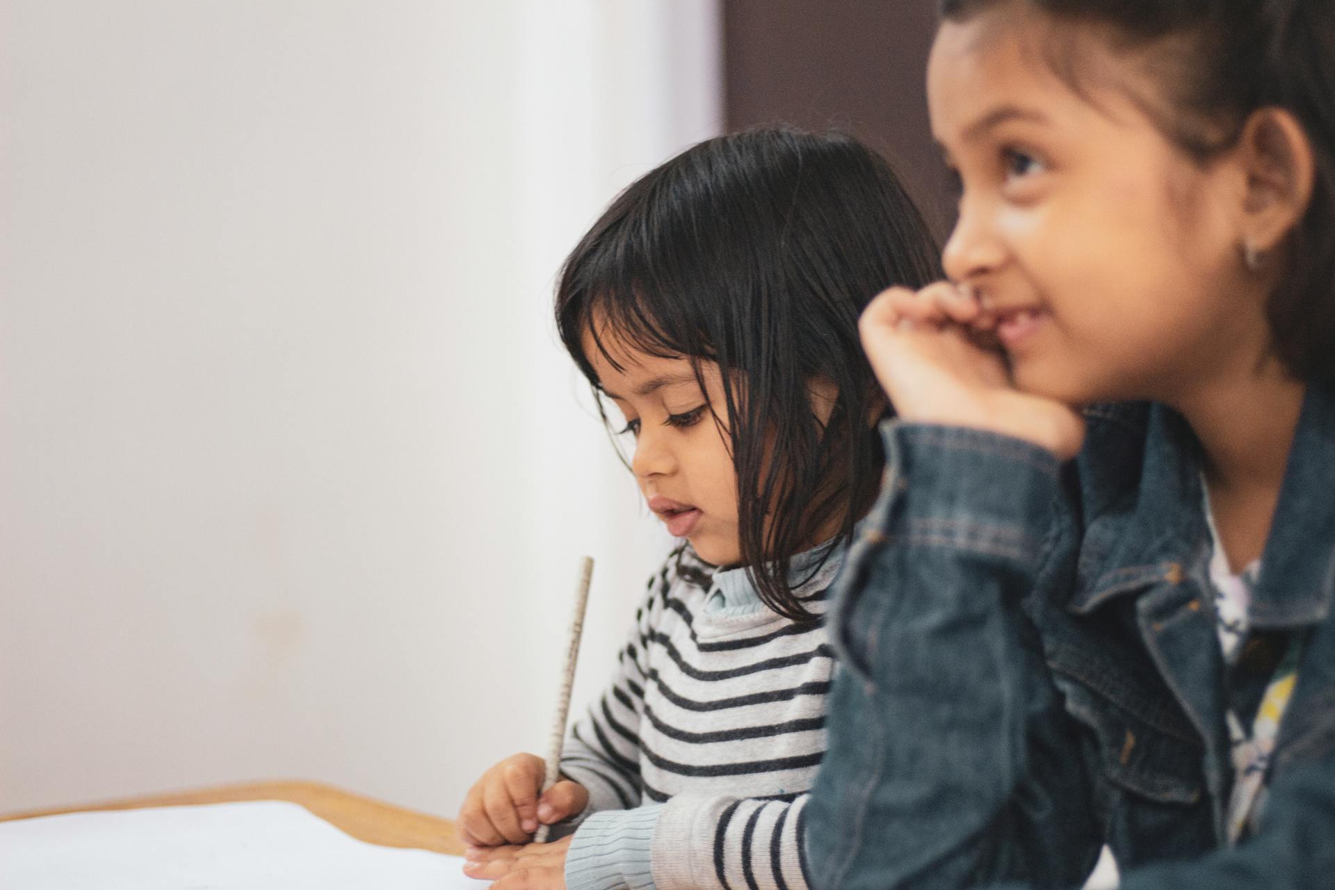 Des filles assises à un bureau, une fille écrivant sur du papier | Source : Pexels