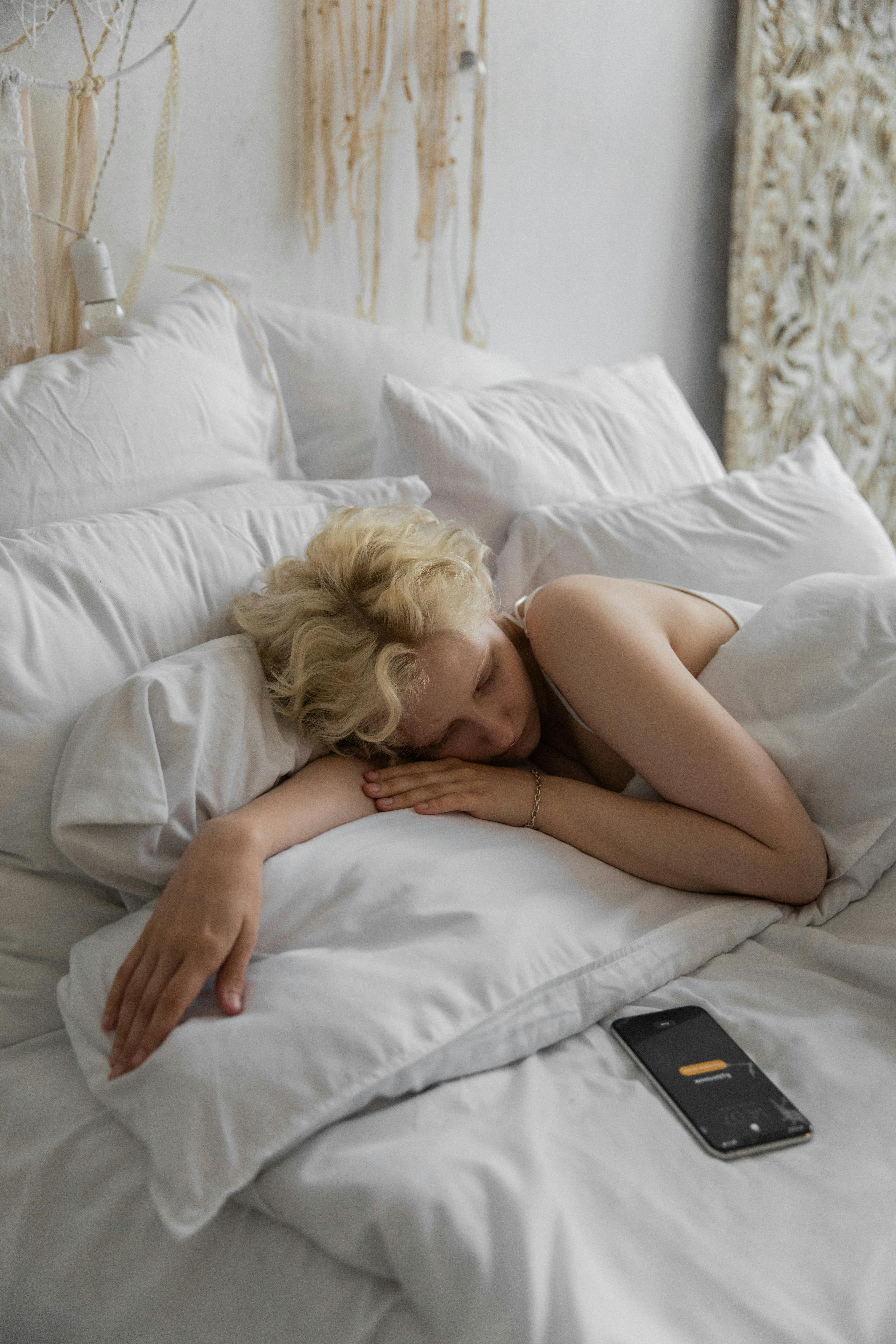 Une femme au lit avec son téléphone sans surveillance | Source : Pexels