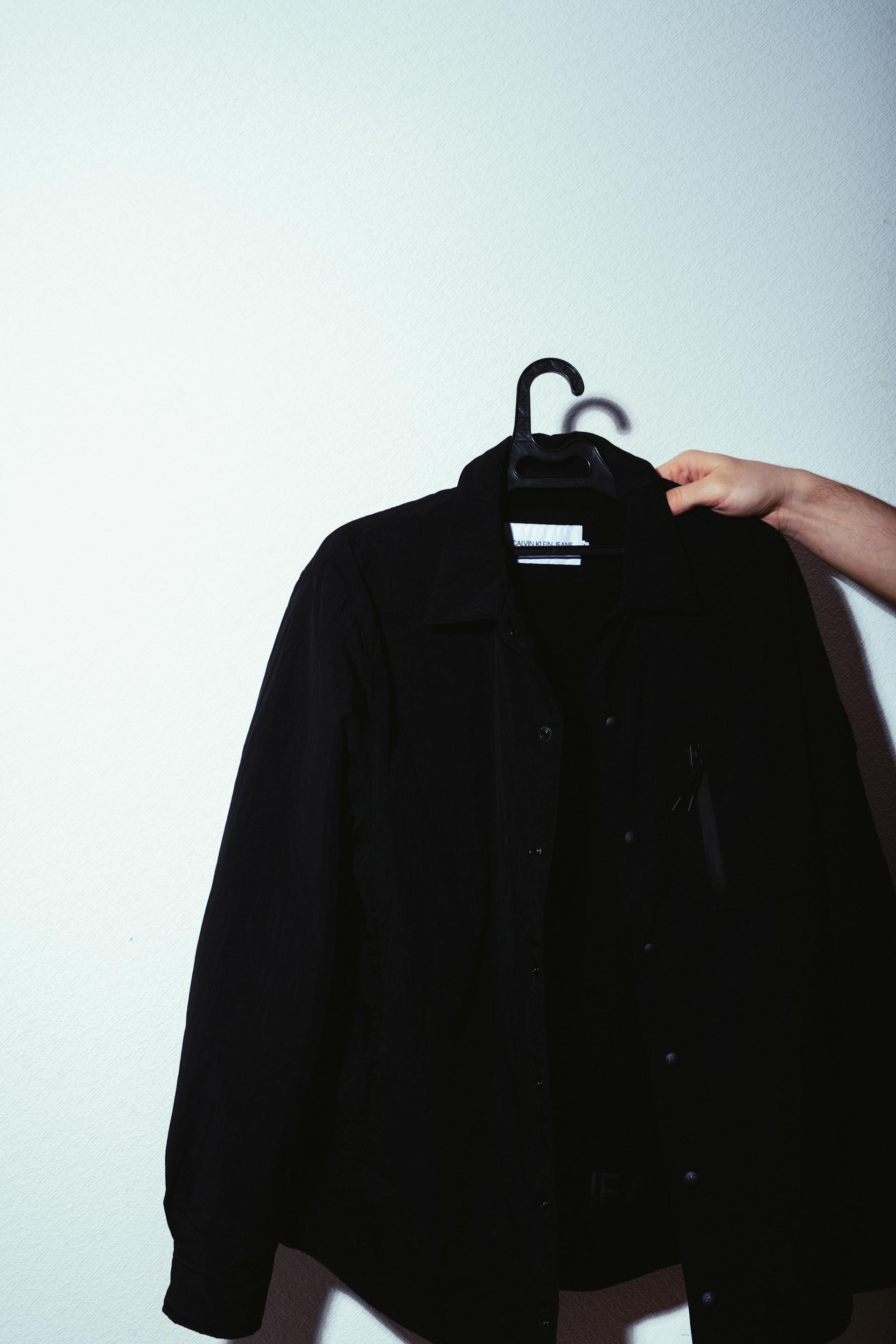 Une personne tenant une veste sur un cintre | Source : Pexels