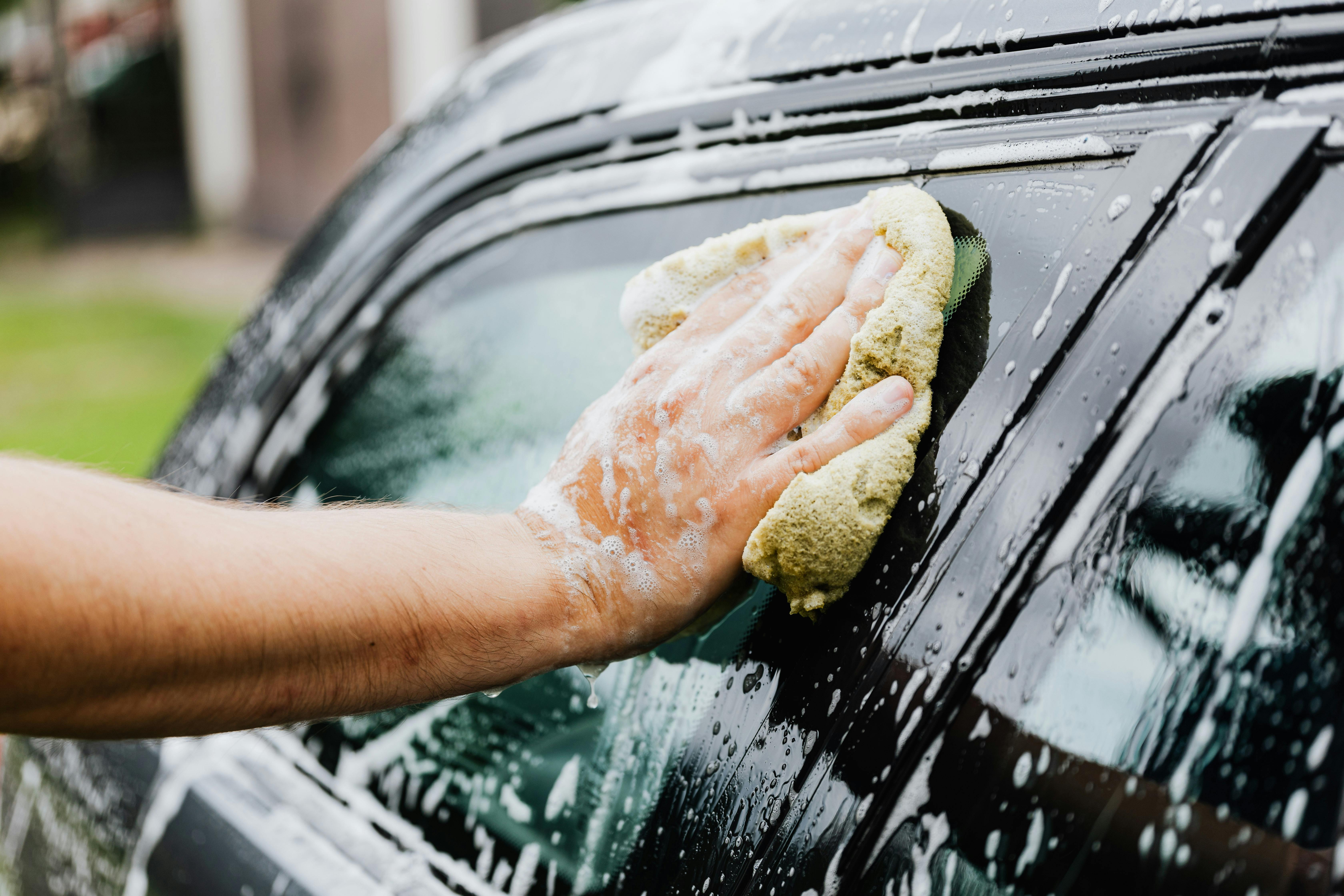 Un homme lave sa voiture | Source : Pexels