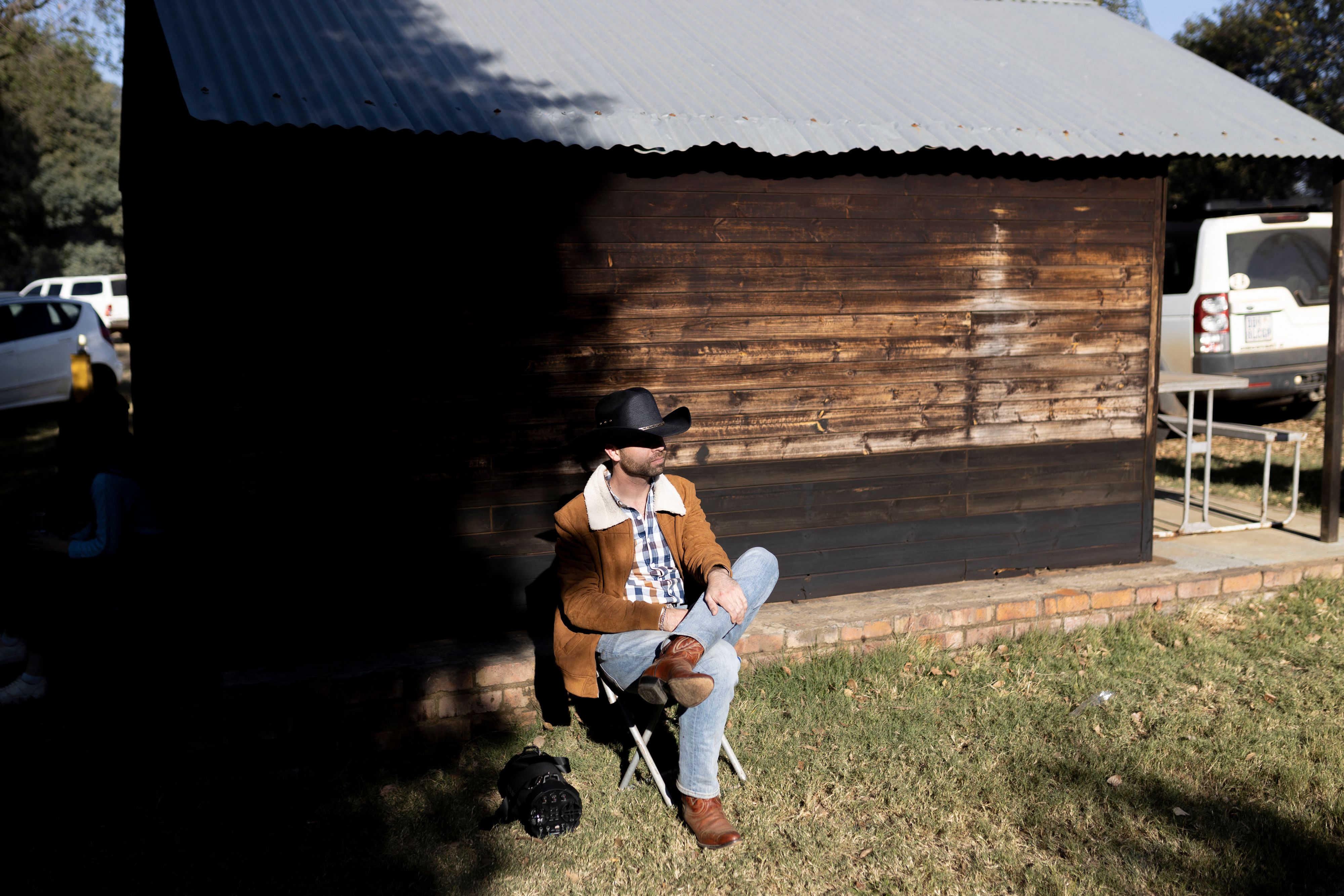 Un homme portant un chapeau de cowboy est assis alors qu'il écoute de la musique. |Photo : Getty Images