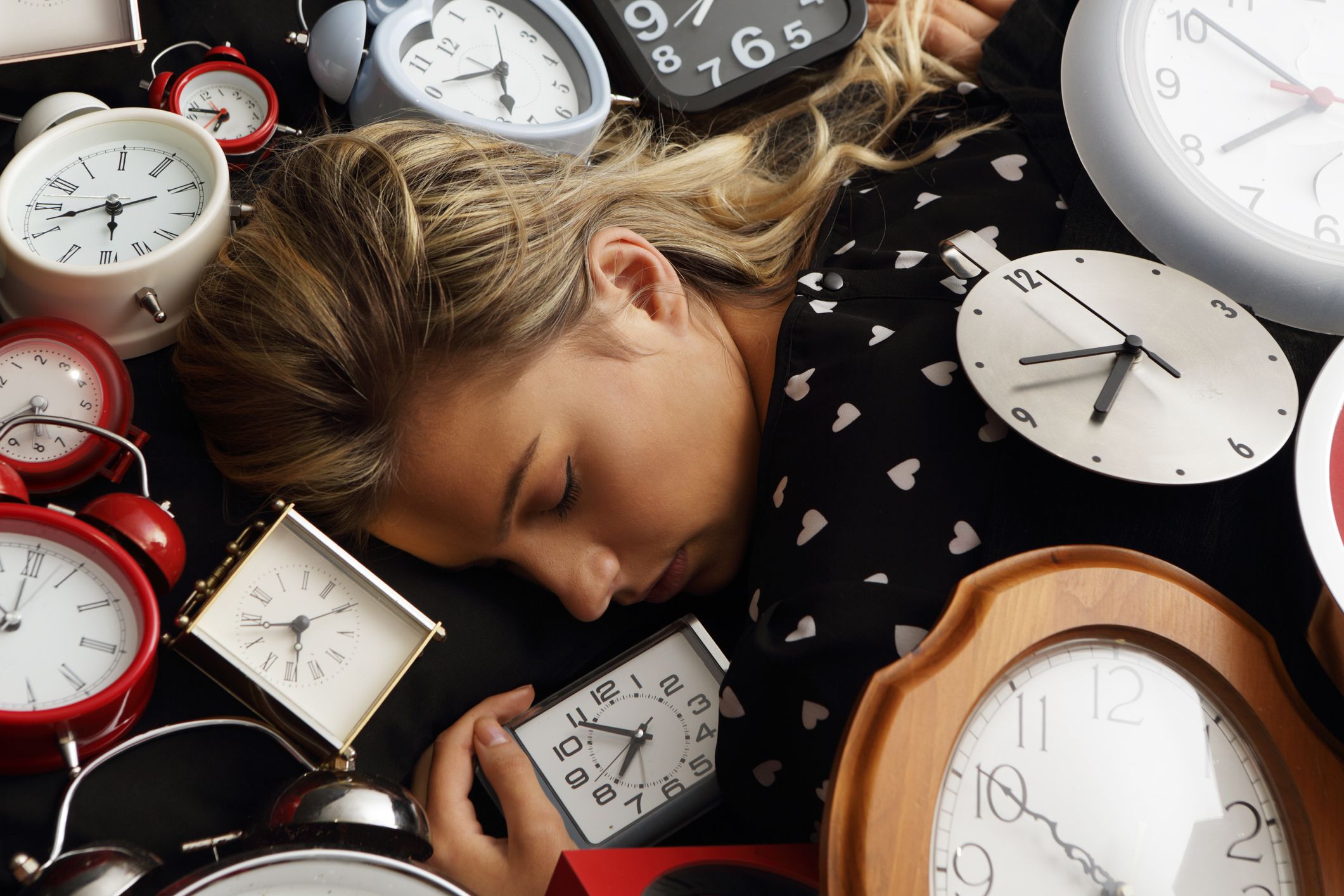 Une femme qui dort avec de nombreuses horloges. | Source : Getty Images