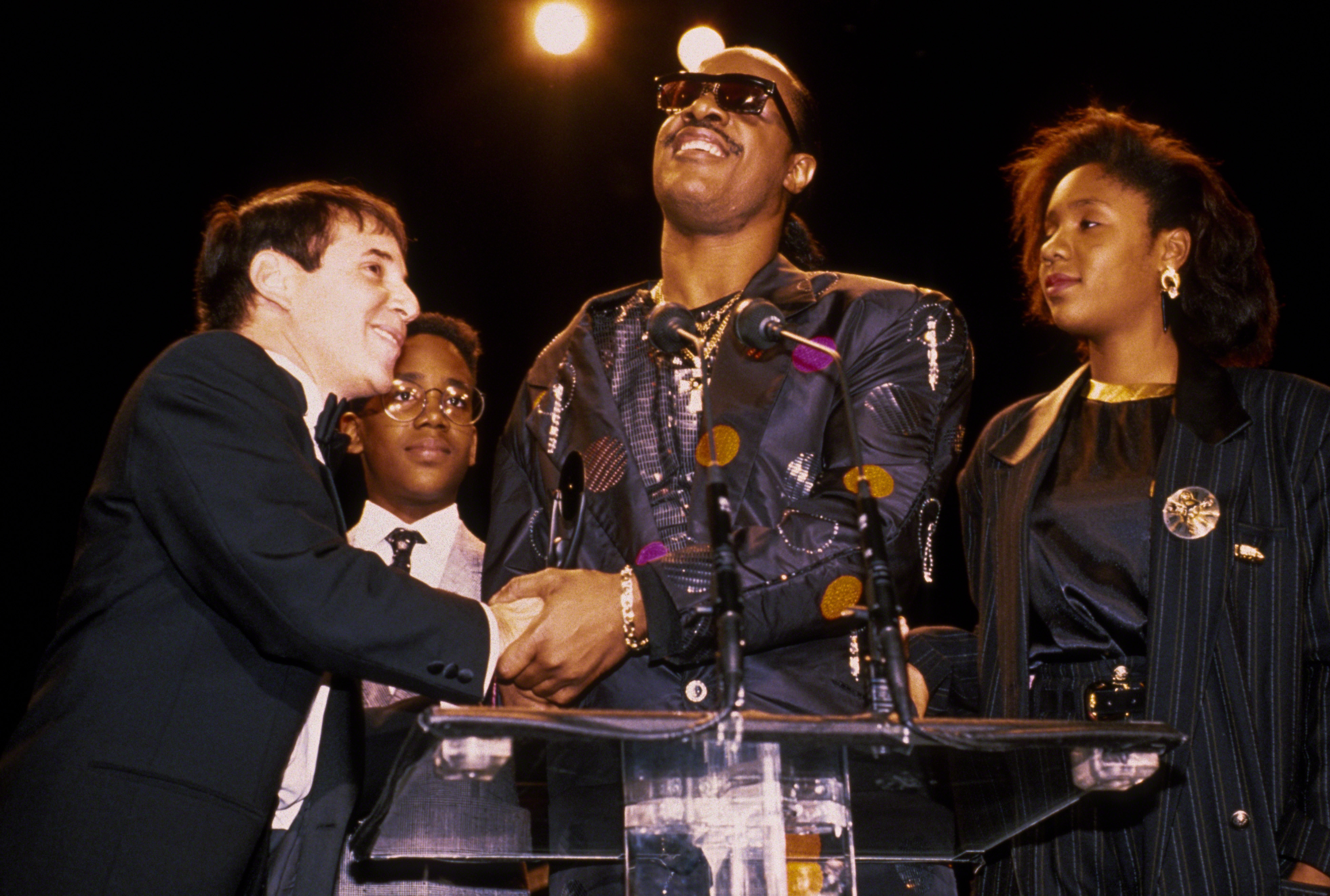 Paul Simon, Keita et Stevie Wonder, et Aisha Morris lors de la cérémonie d'intronisation au Rock N Roll Hall of Fame le 1er janvier 1989 à New York. | Source : Getty Images