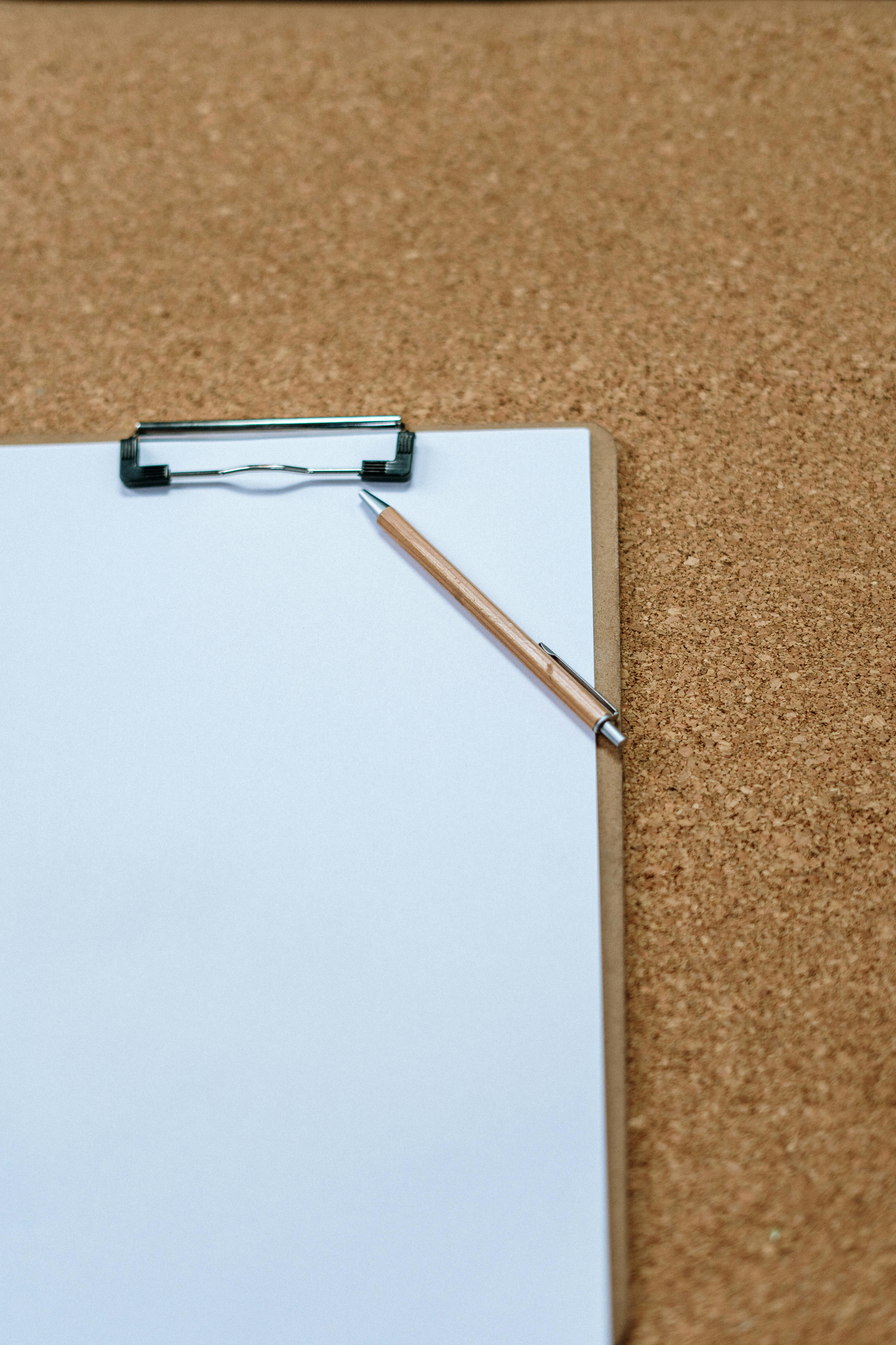 Papier et stylo sur un tapis brun | Source : Pexels