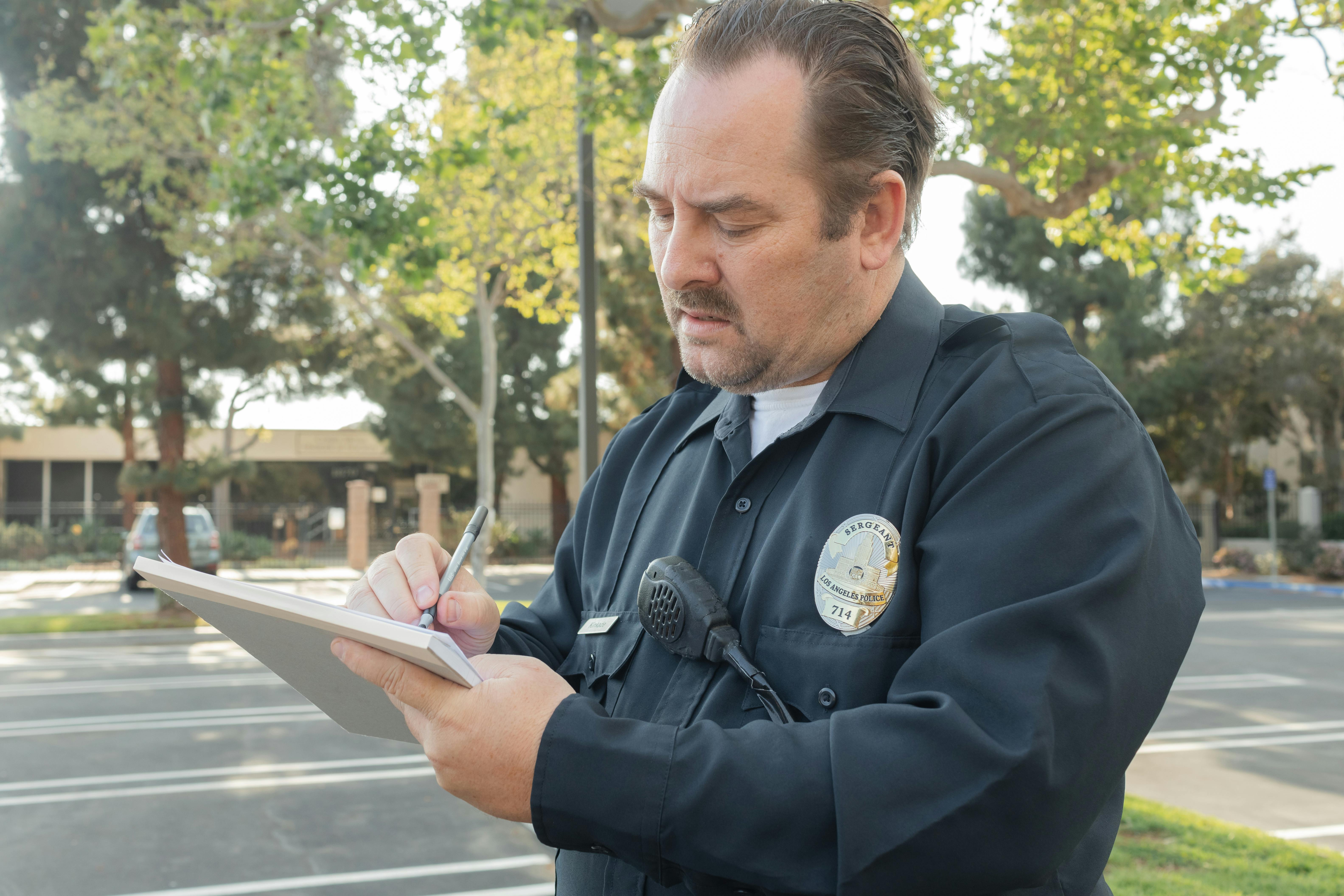 Un policier qui écrit quelque chose dans son bloc-notes | Source : Pexels