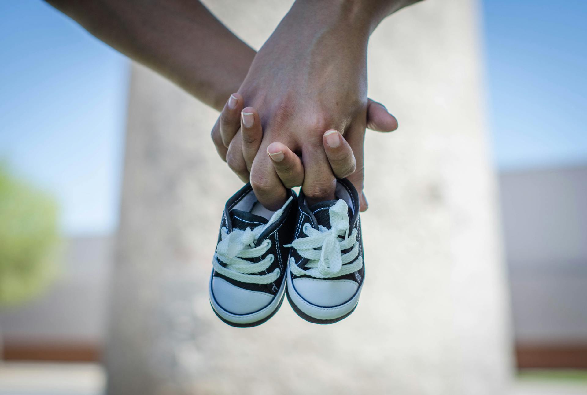 Un couple tenant des chaussures de bébé | Source : Pexels