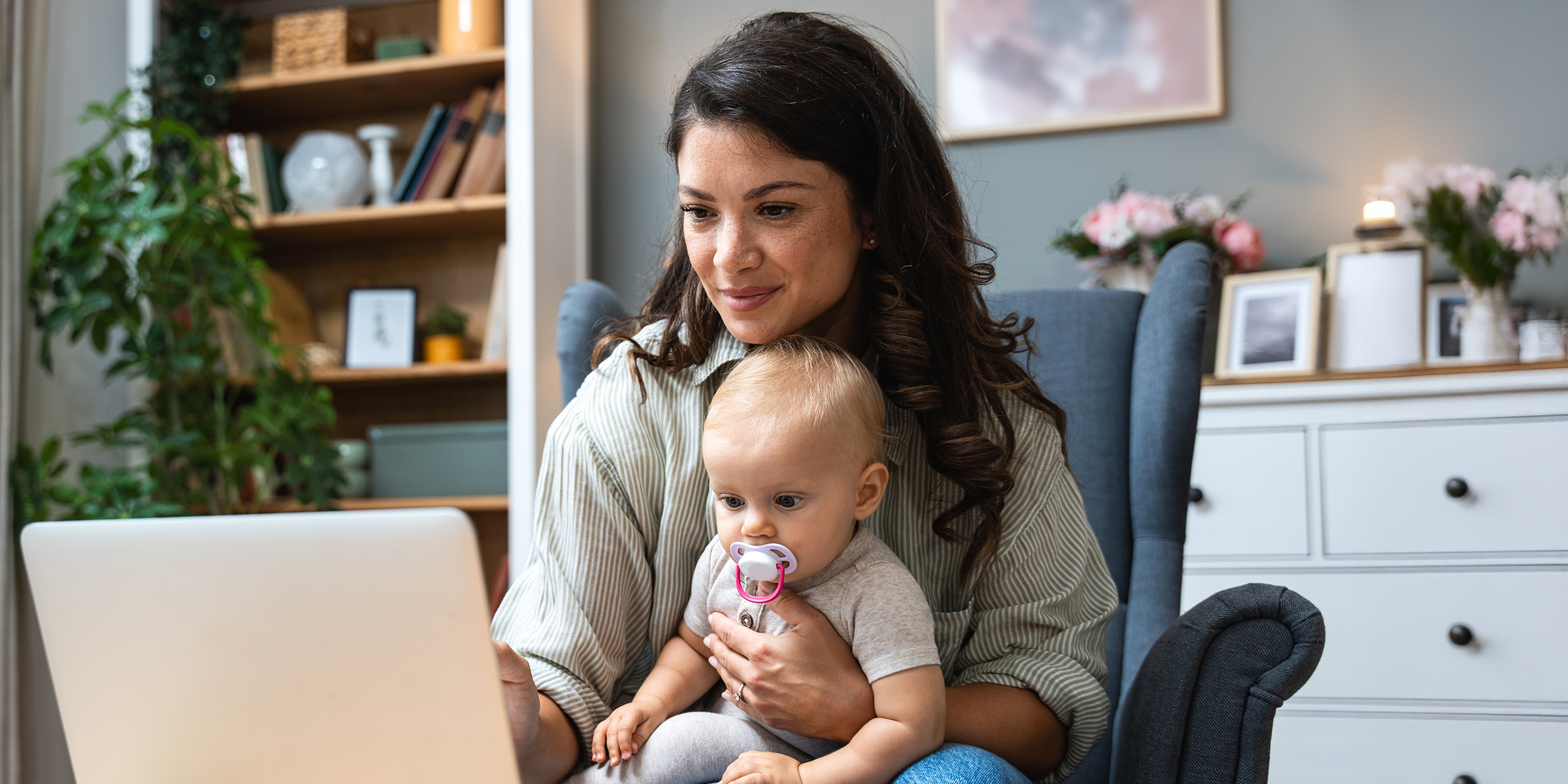 Une femme et son nouveau-né devant un PC | Source : Shutterstock