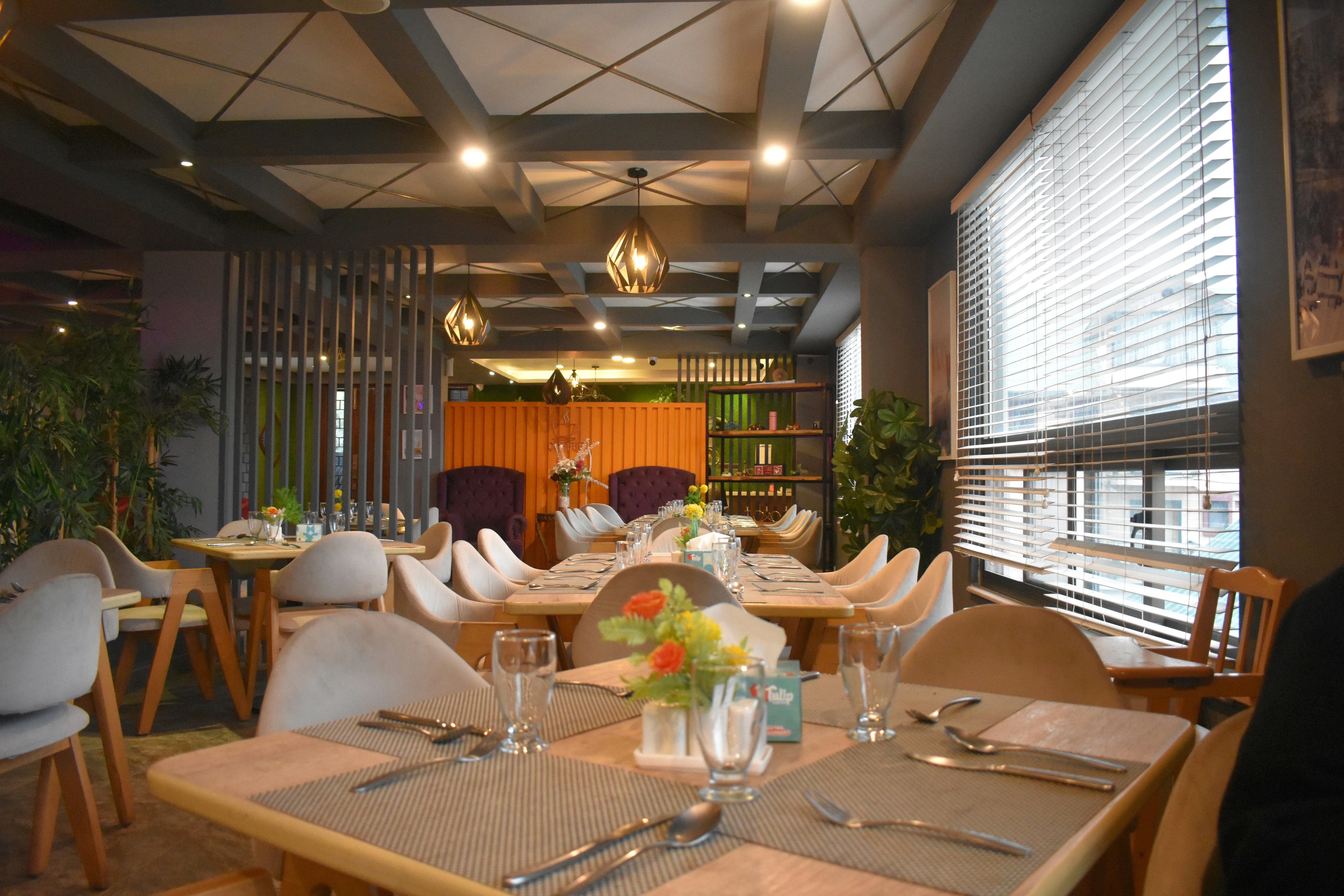 Intérieur de restaurant chaleureux et chic, avec d'élégantes tables en bois | Source : Pexels