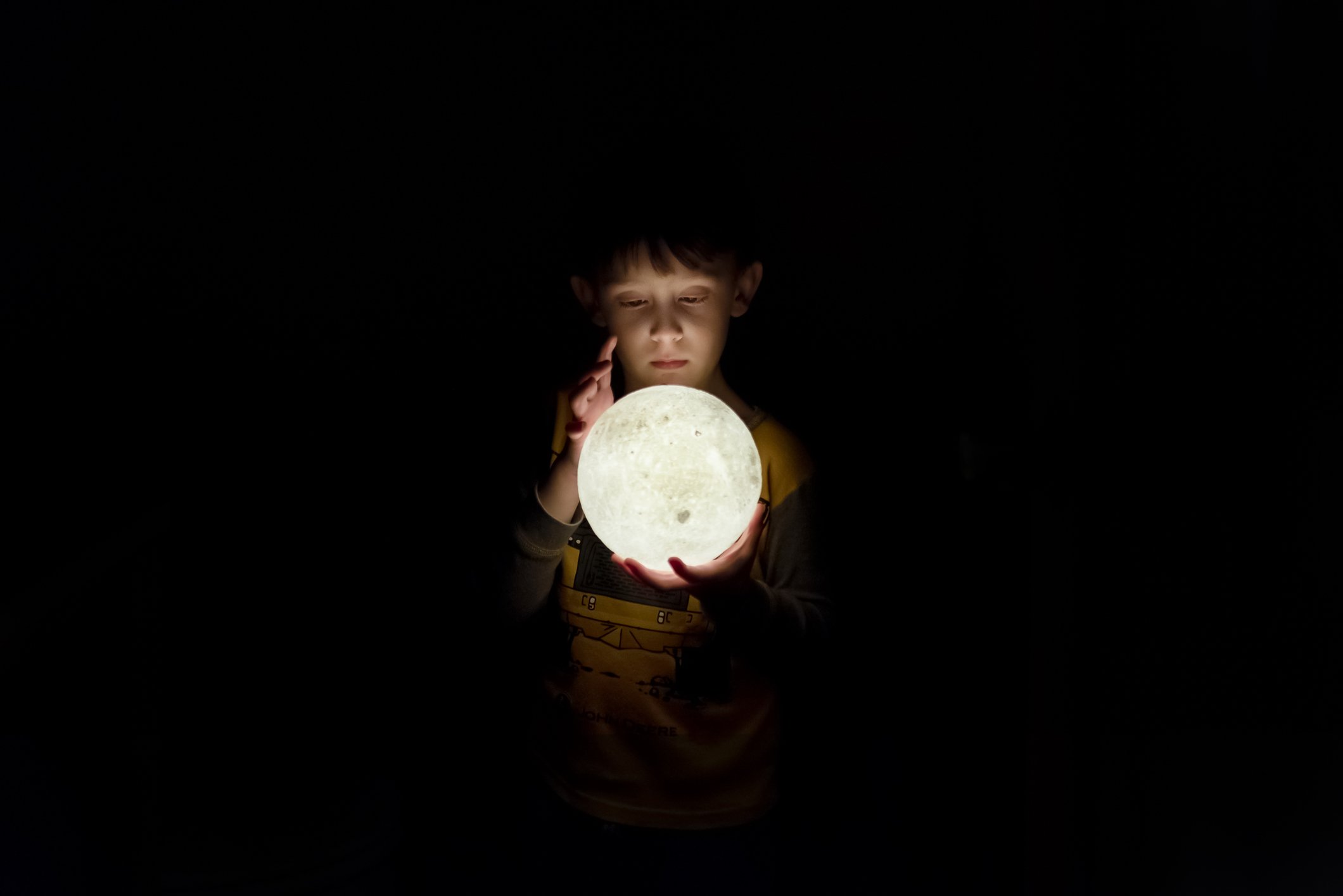 Un jeune garçon regardant dans une lampe de lune 3D. | Photo: Getty Images