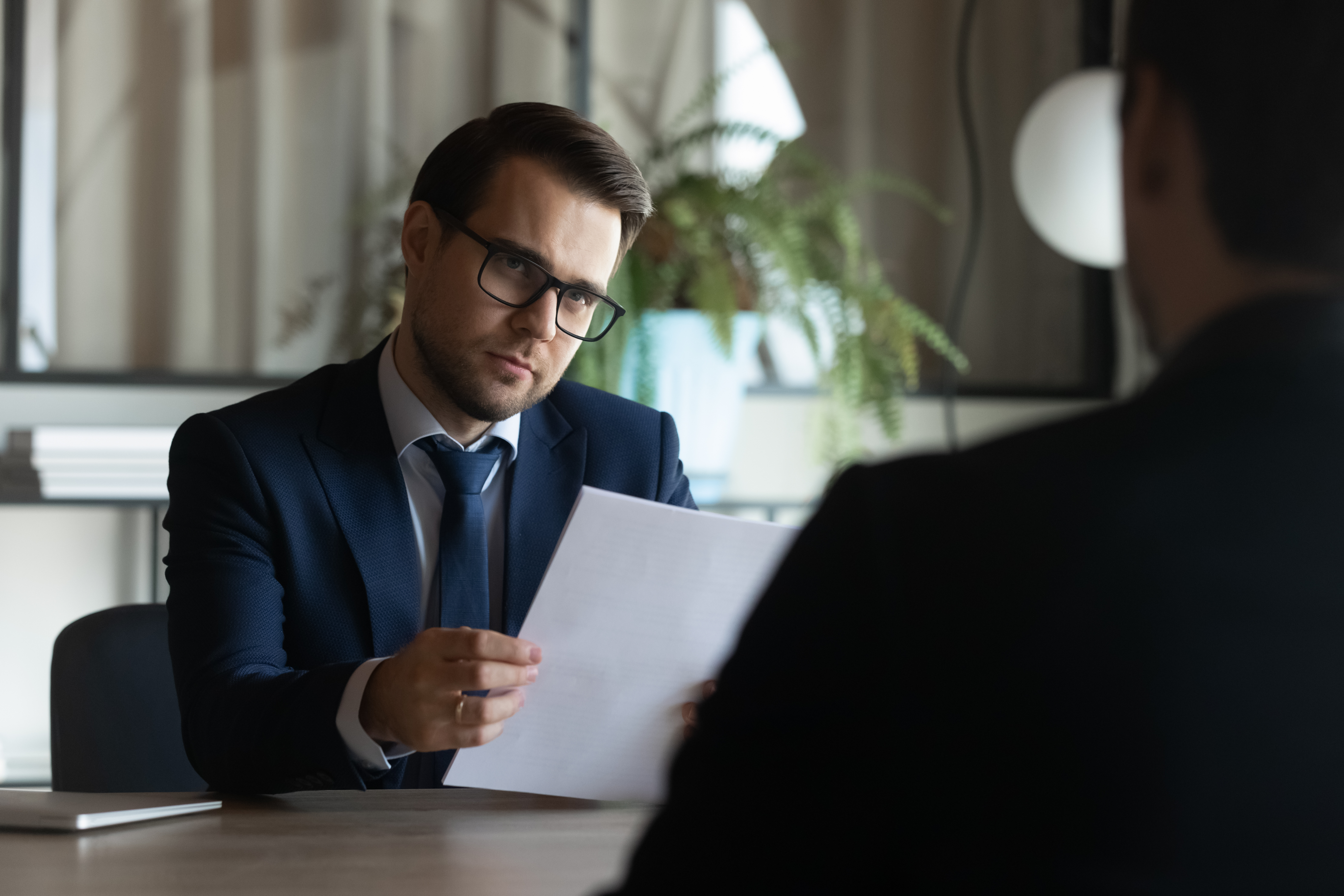 Gerente homem está sentado atrás da mesa | Fonte: Shutterstock.com