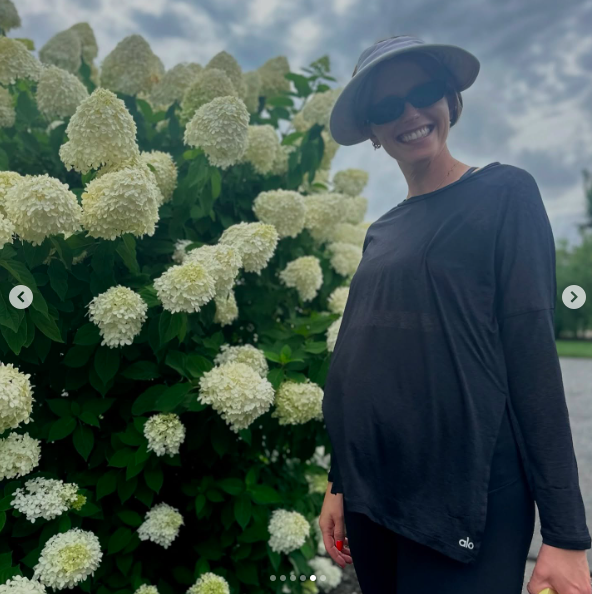 Katherine Schwarzenegger sourit alors qu'elle se tient à côté de fleurs. | Source : Instagram/prattprattpratt