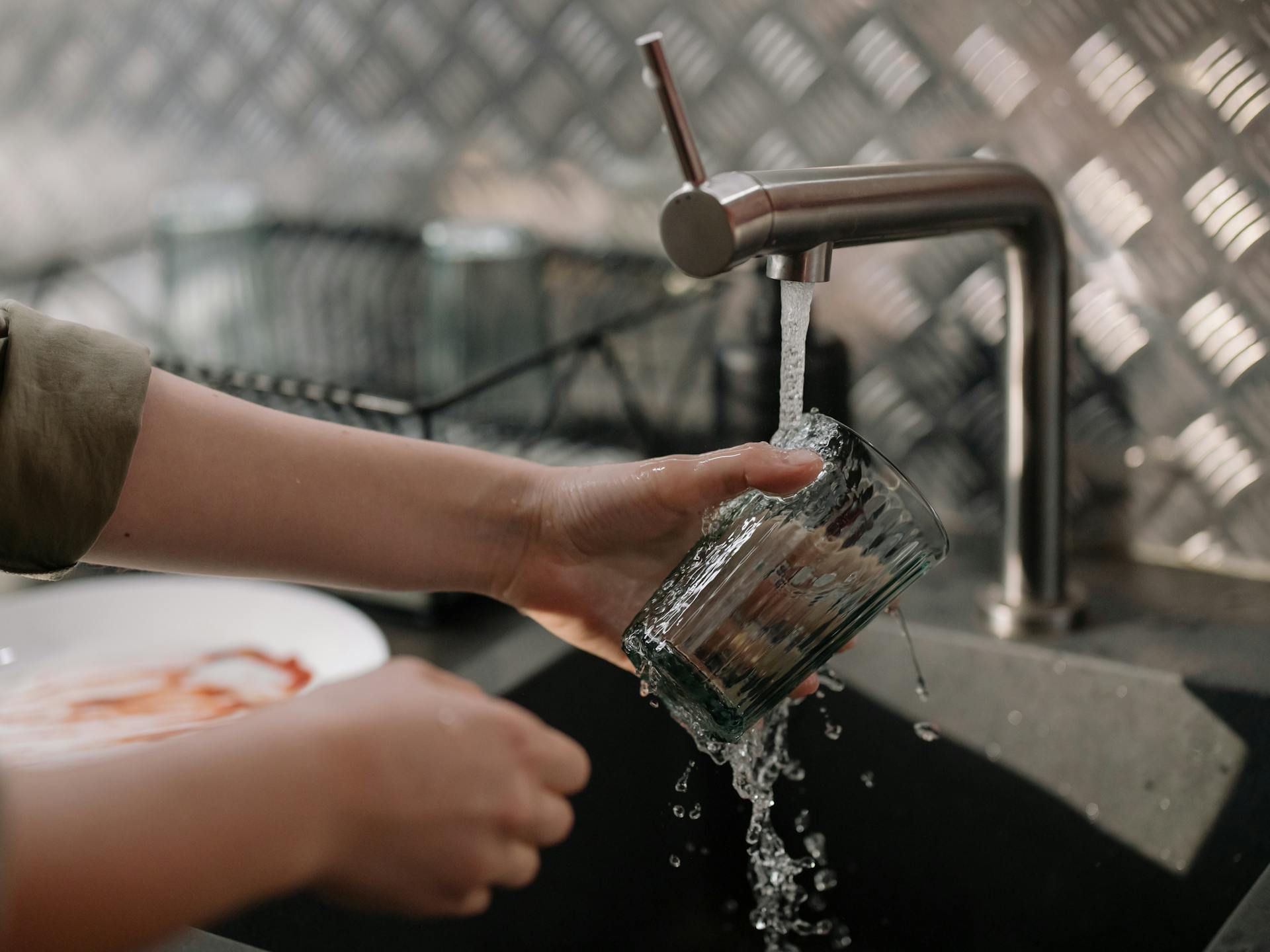 Un homme lave un verre | Source : Pexels