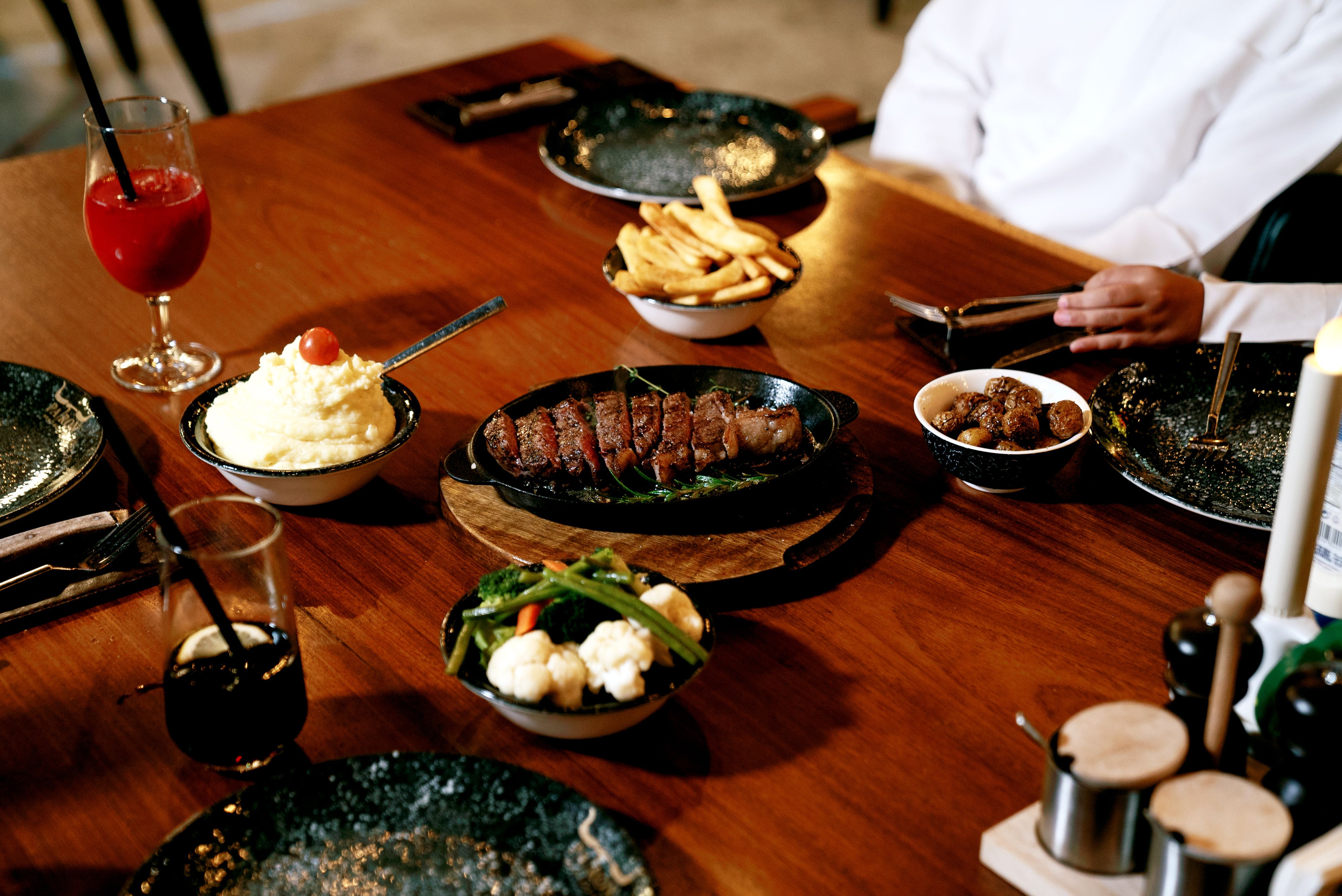 Un délicieux plat gastronomique composé d'un steak, de frites et de légumes, servi sur une table en bois | Source : Pexels