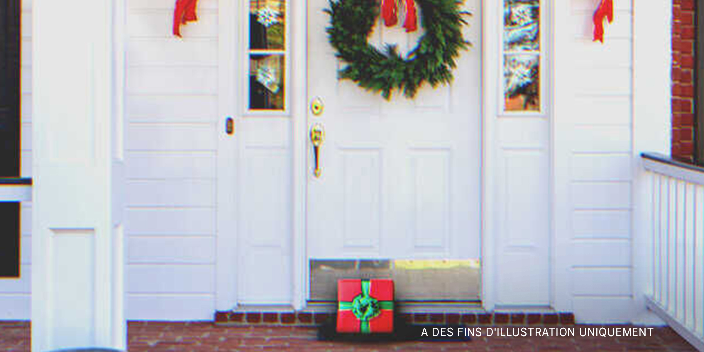 Un cadeau posé devant près d'une porte d'entrée | Source : Shutterstock