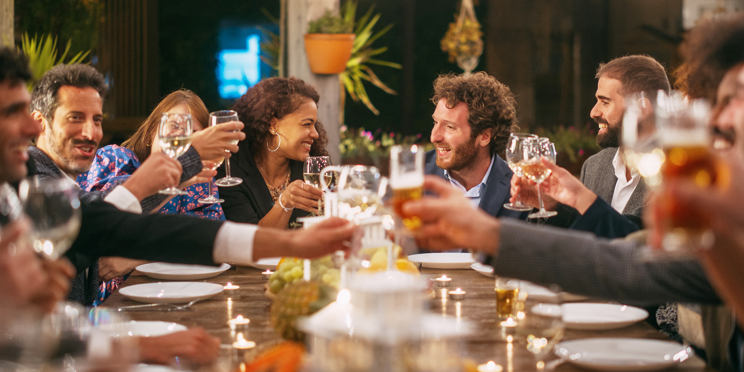 Des invités portent un toast lors d'un dîner | Source : Shutterstock