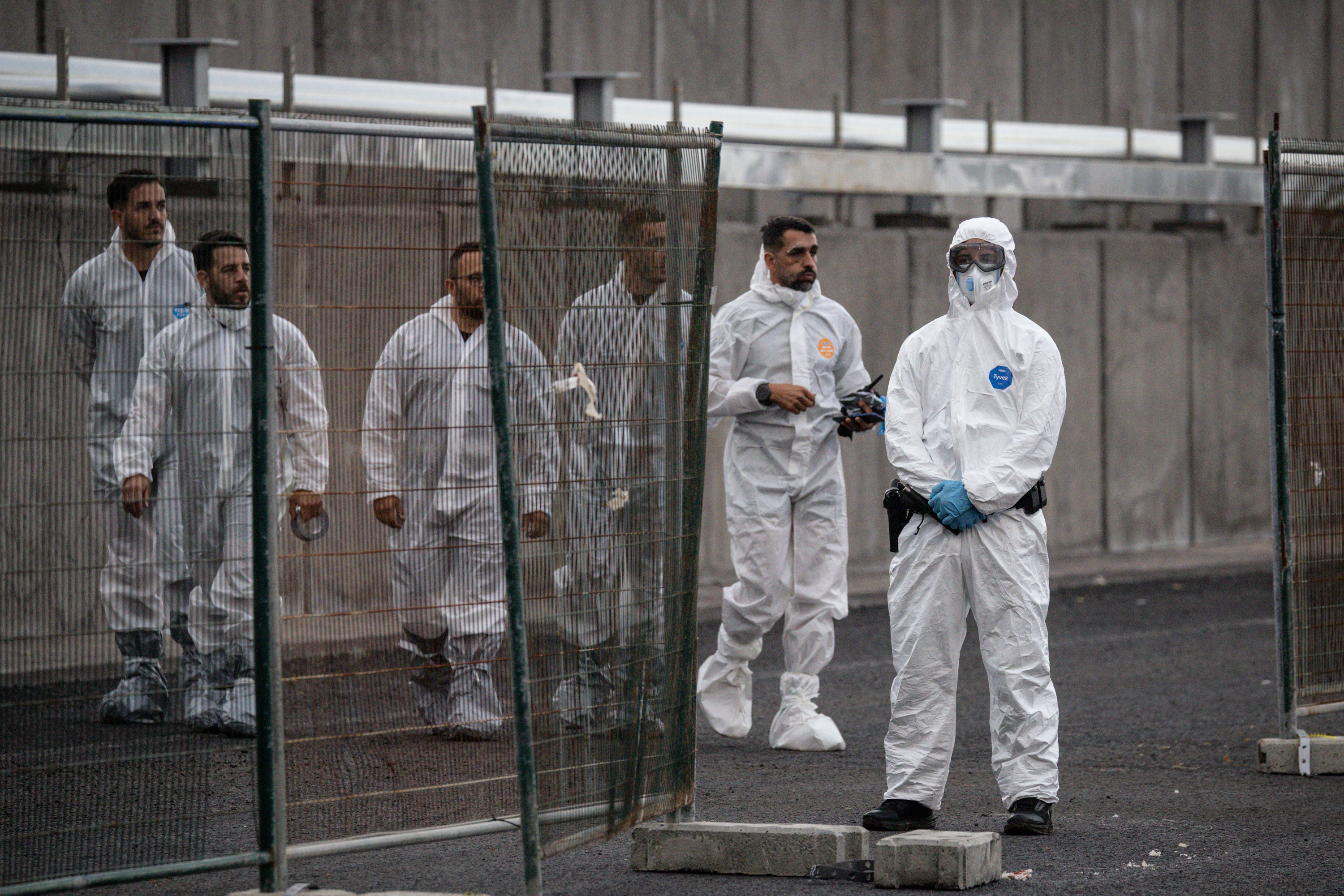 Des ouvriers arrivent vêtus de tenues de protection après l'accostage du MV Hondius au port de Granadilla, le 10 mai 2026, à Tenerife, dans l'archipel des Canaries, en Espagne. | Source : Getty Images
