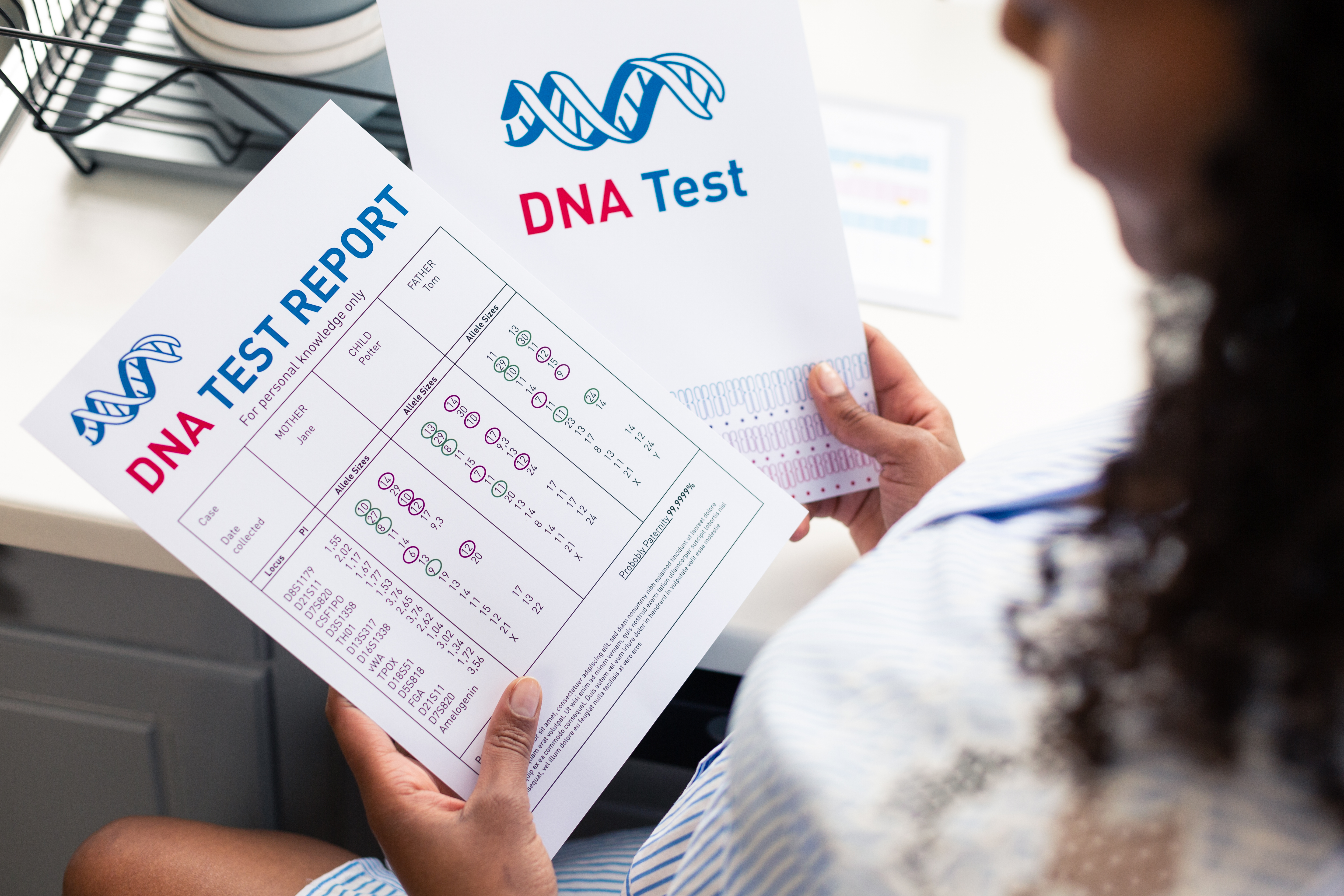 Une femme tenant deux rapports de tests ADN dans ses mains | Source : Shutterstock