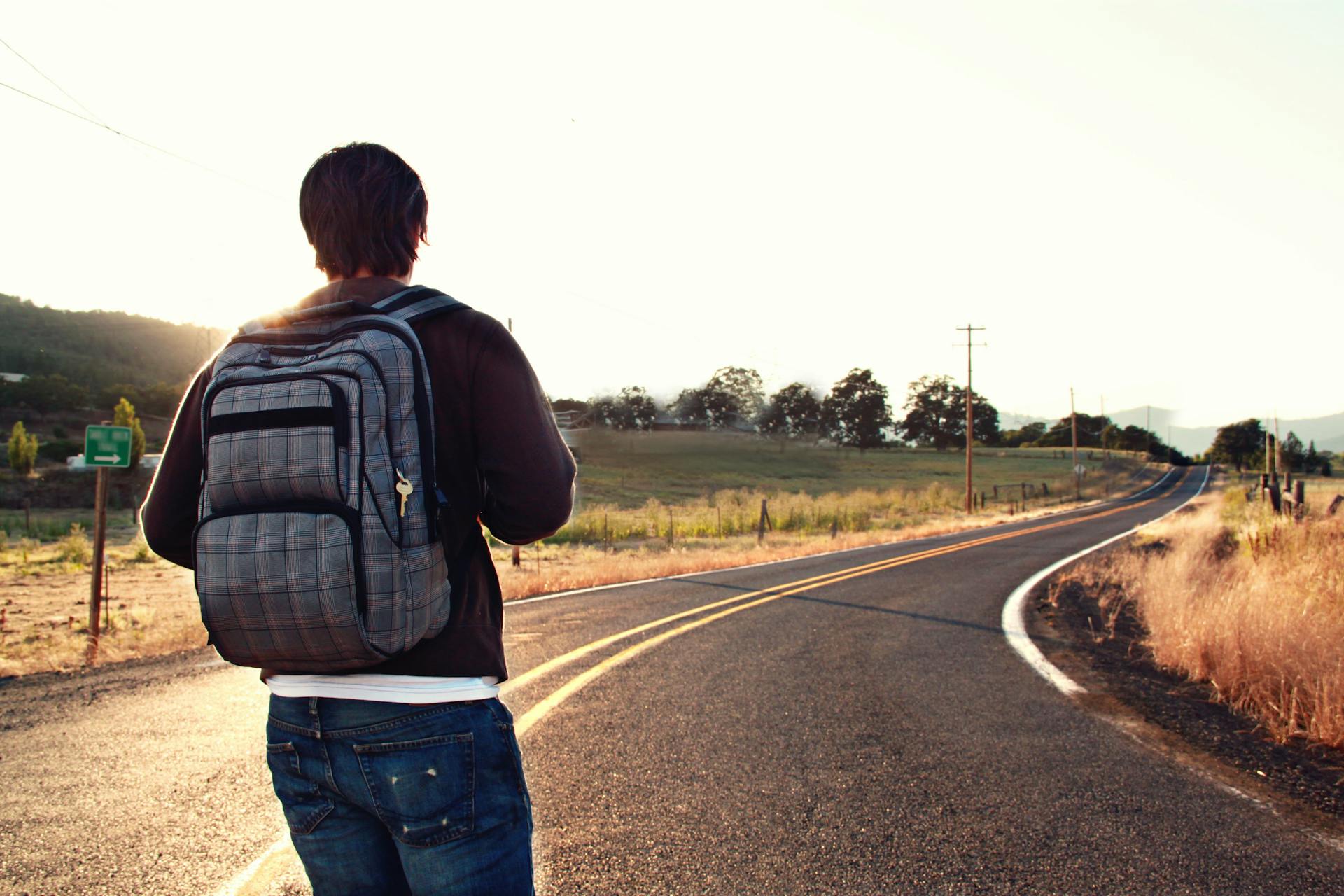 Un homme avec un sac à dos debout sur une route | Source : Pexels