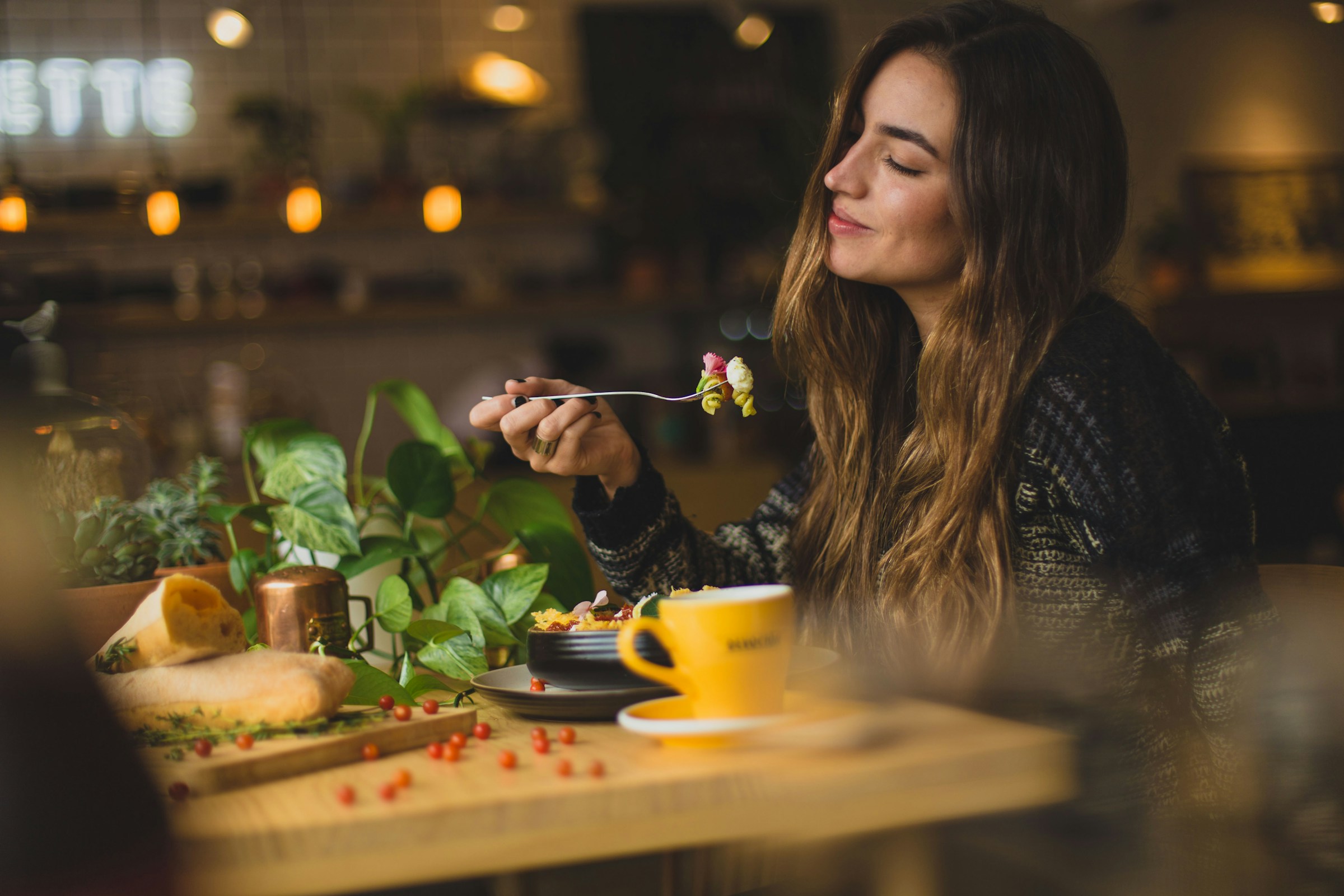 Une femme mangeant dans un restaurant | Source : Unsplash