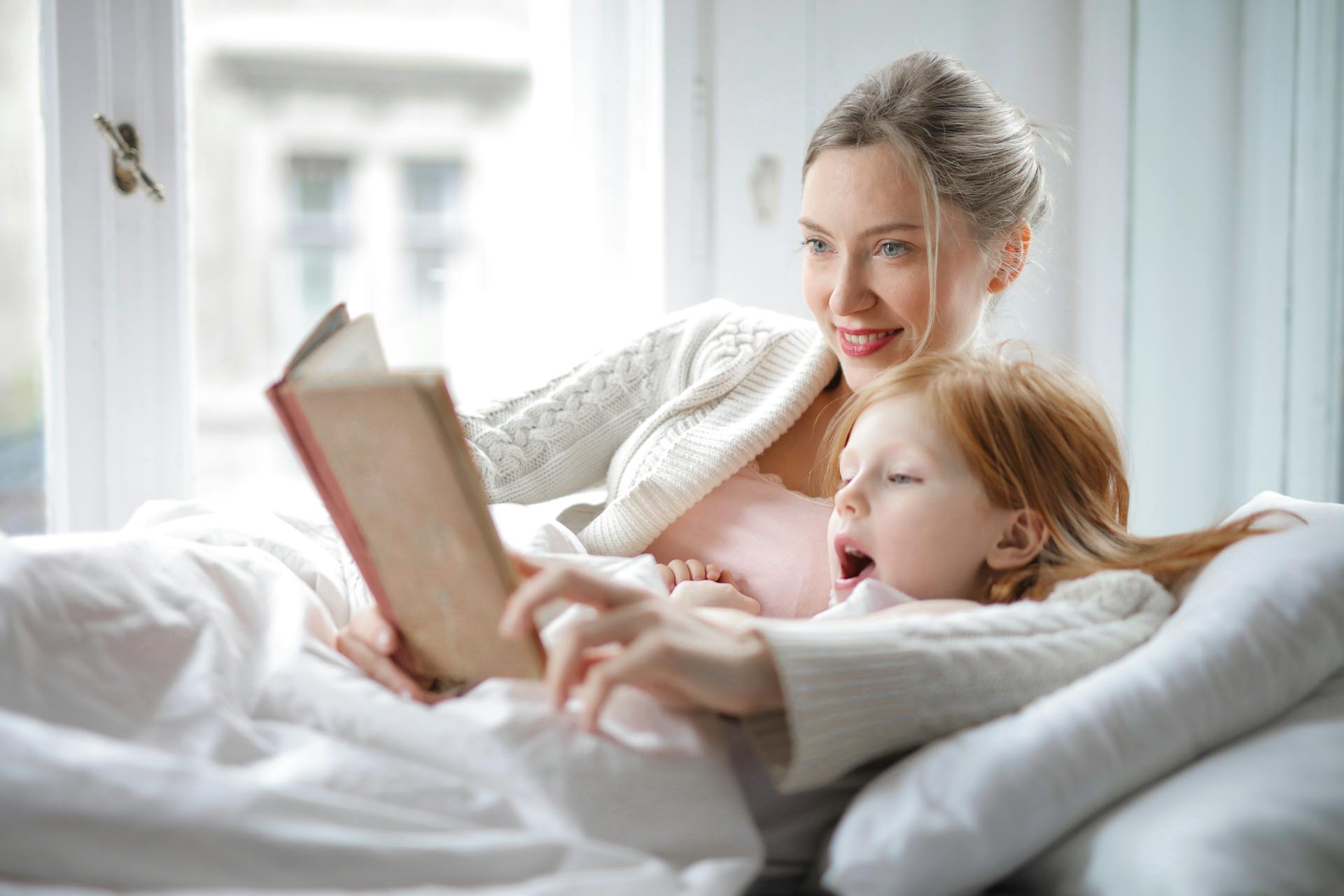 Une femme fait la lecture à sa fille | Source : Pexels