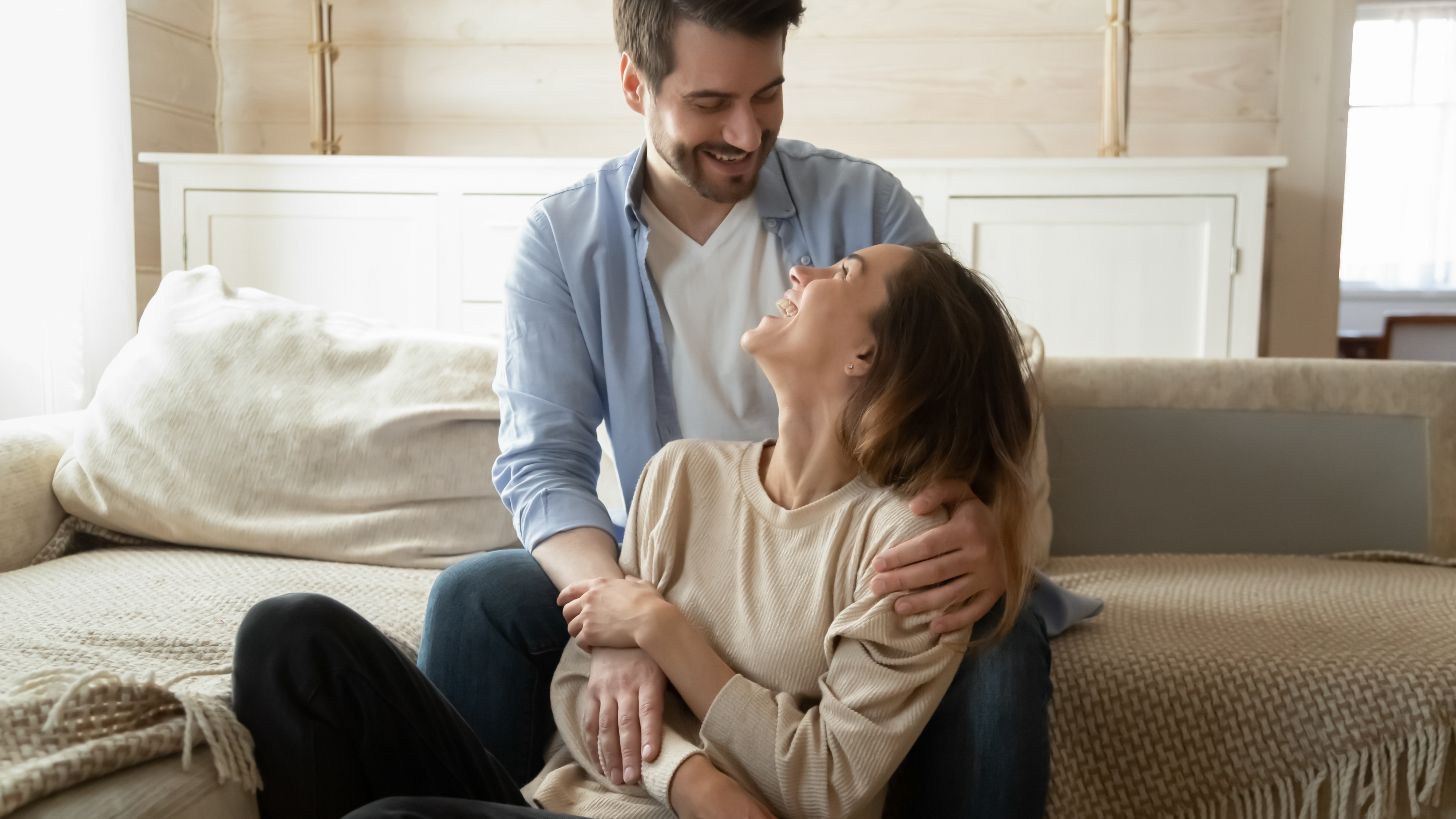 Un couple se tenant par la main et se faisant des câlins à la maison | Source : Shutterstock