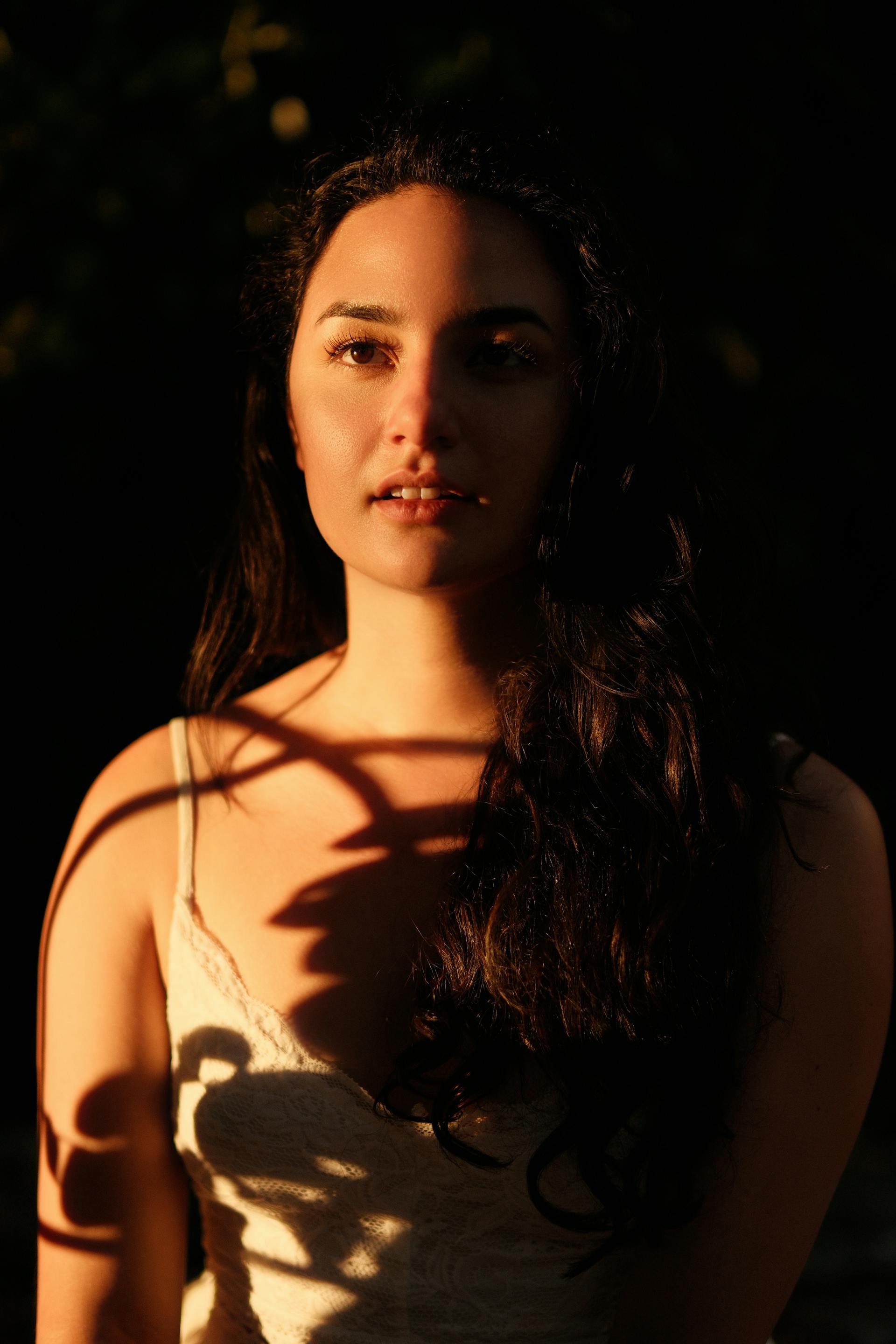 Portrait d'une jeune femme avec des ombres qui tombent sur son corps | Source : Pexels