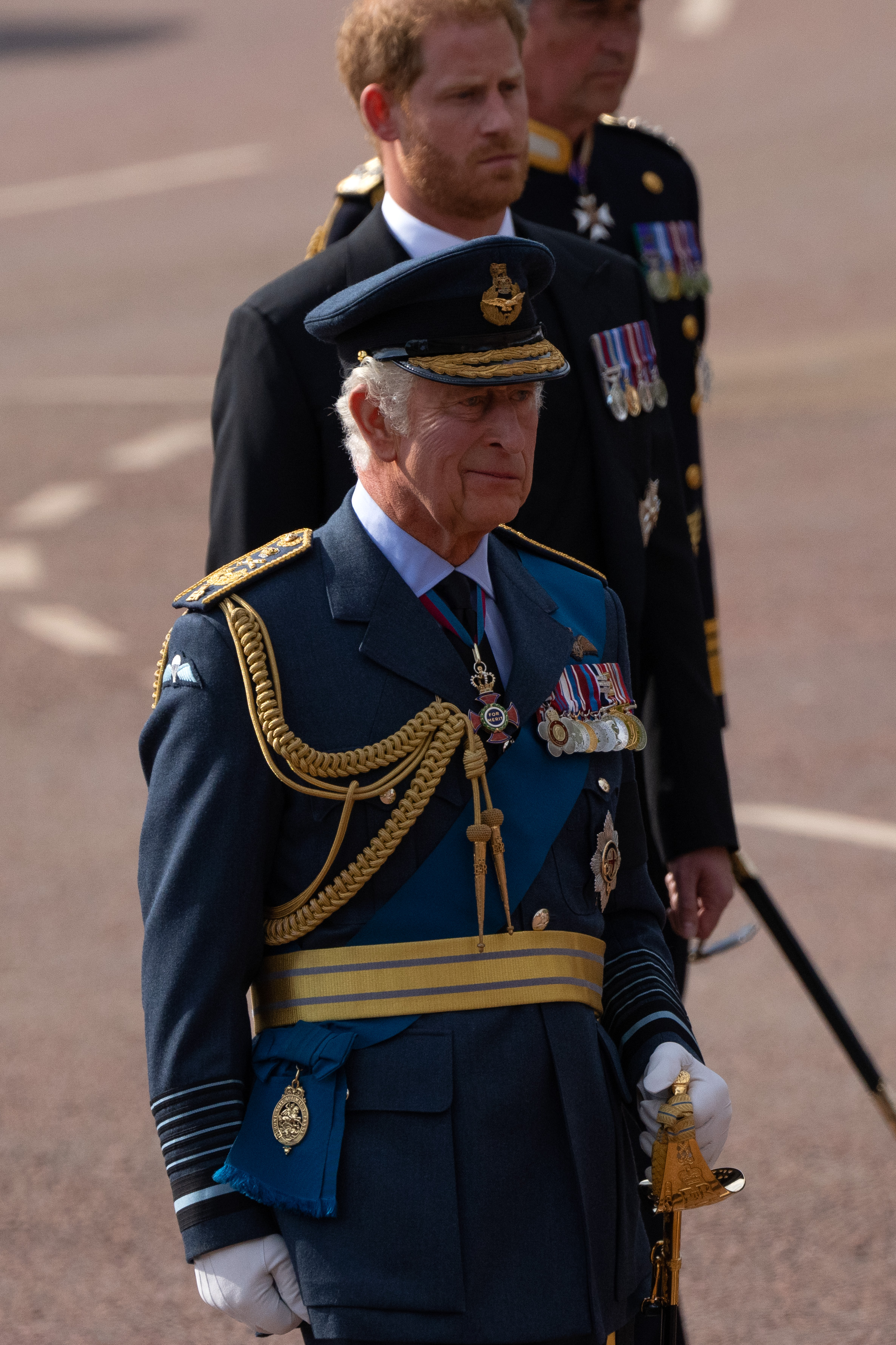 Le roi Charles III se tient devant son fils, le prince Harry, lors de la procession cérémonielle de la défunte reine Élisabeth II à Londres, en Angleterre, le 14 septembre 2022. | Source : Getty Images