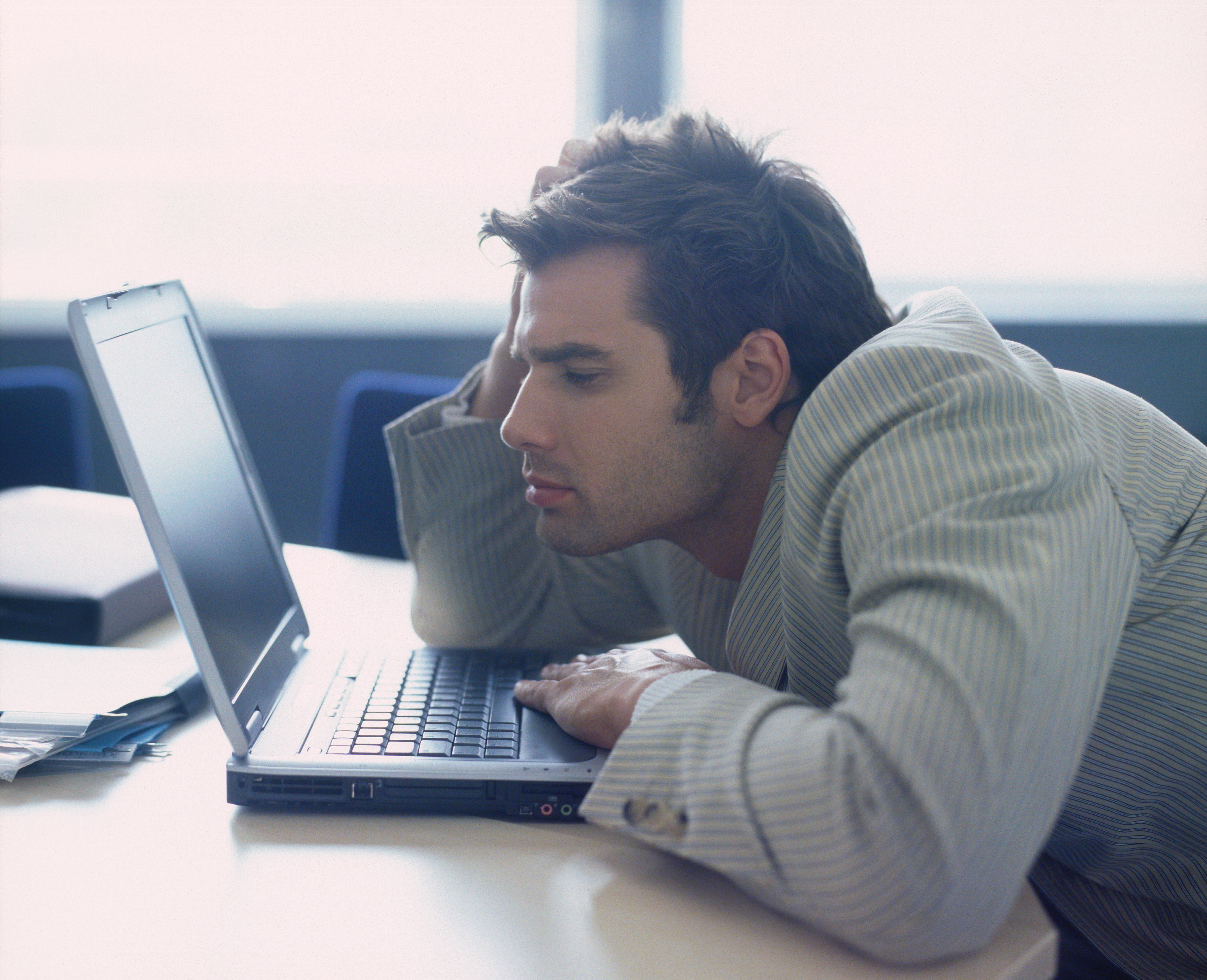 Un homme avachi devant son ordinateur portable | Source : Shutterstock