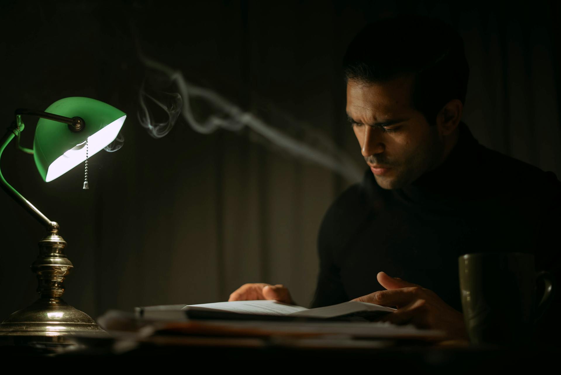 Un homme lisant un journal intime dans une pièce sombre | Source : Pexels