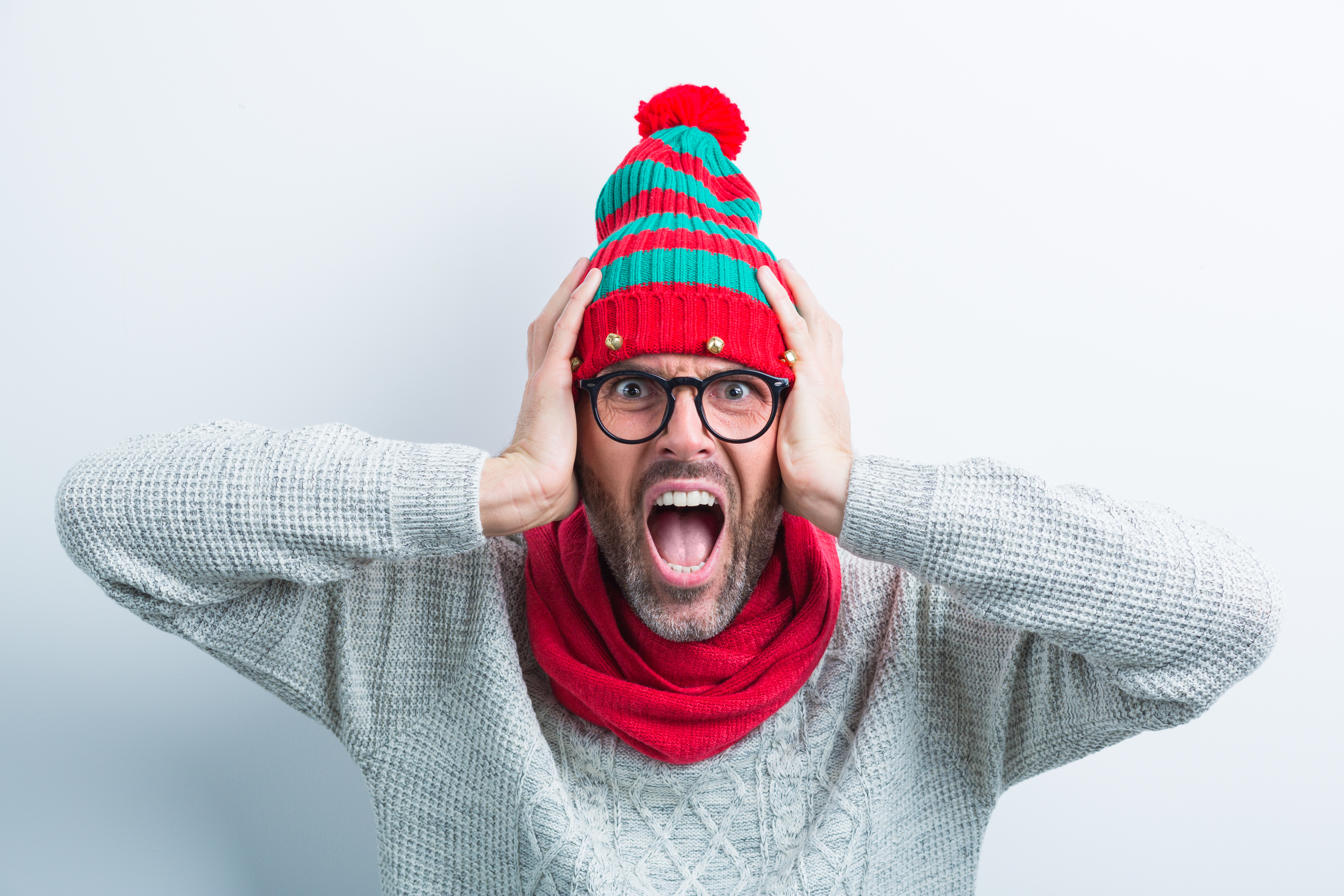 Homme hurlant avec un bonnet de Noël | Source : Getty Images