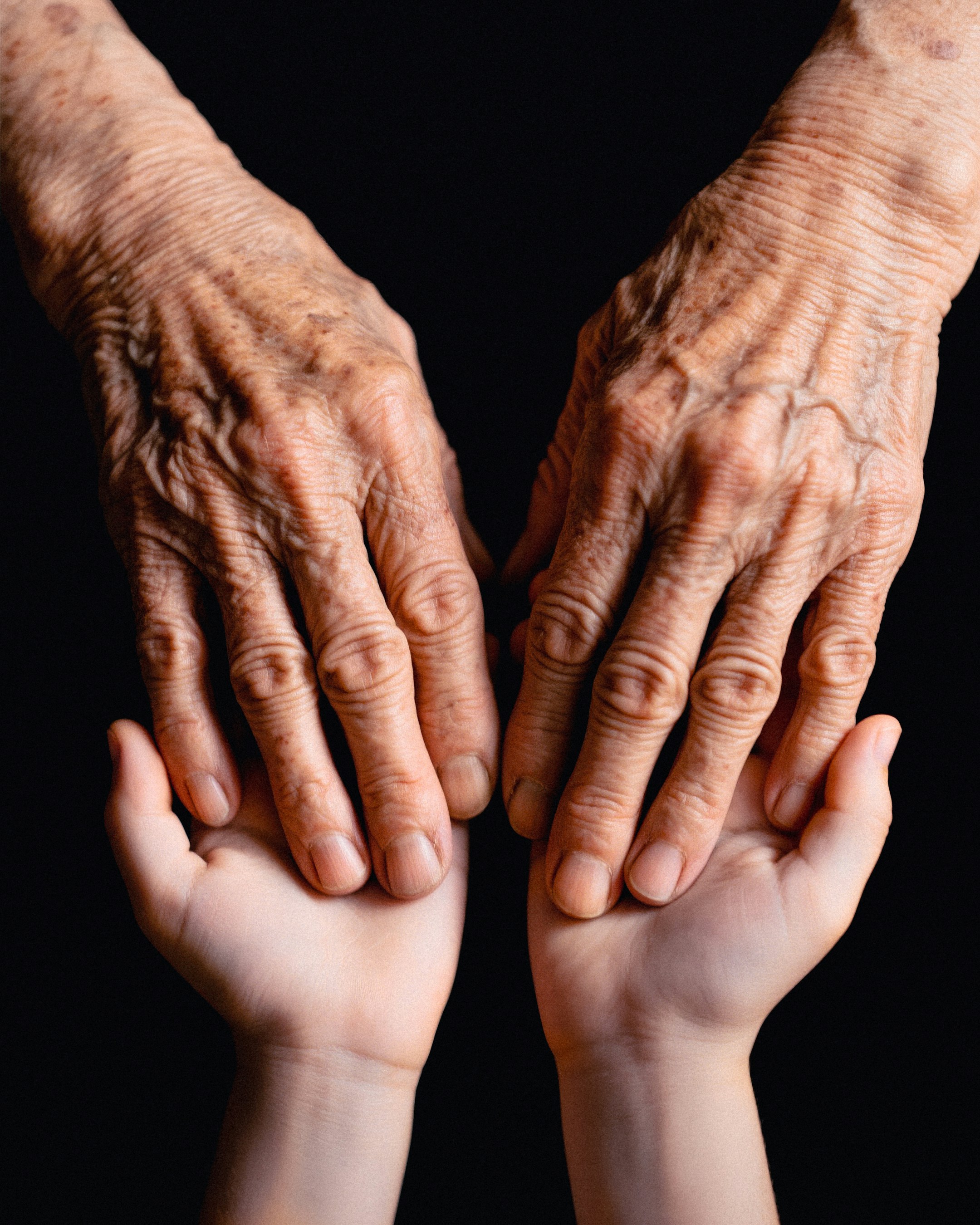 Les mains d'un jeune et d'une personne plus âgée se touchent | Source : Unsplash