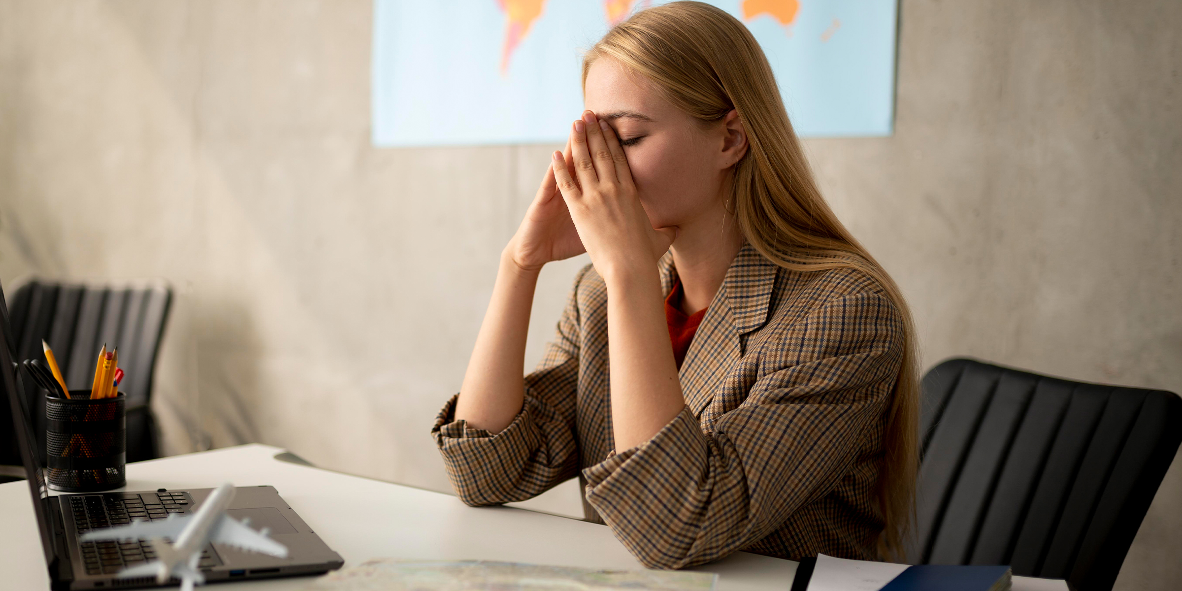 Une femme frustrée assise à un bureau | Source : Freepik