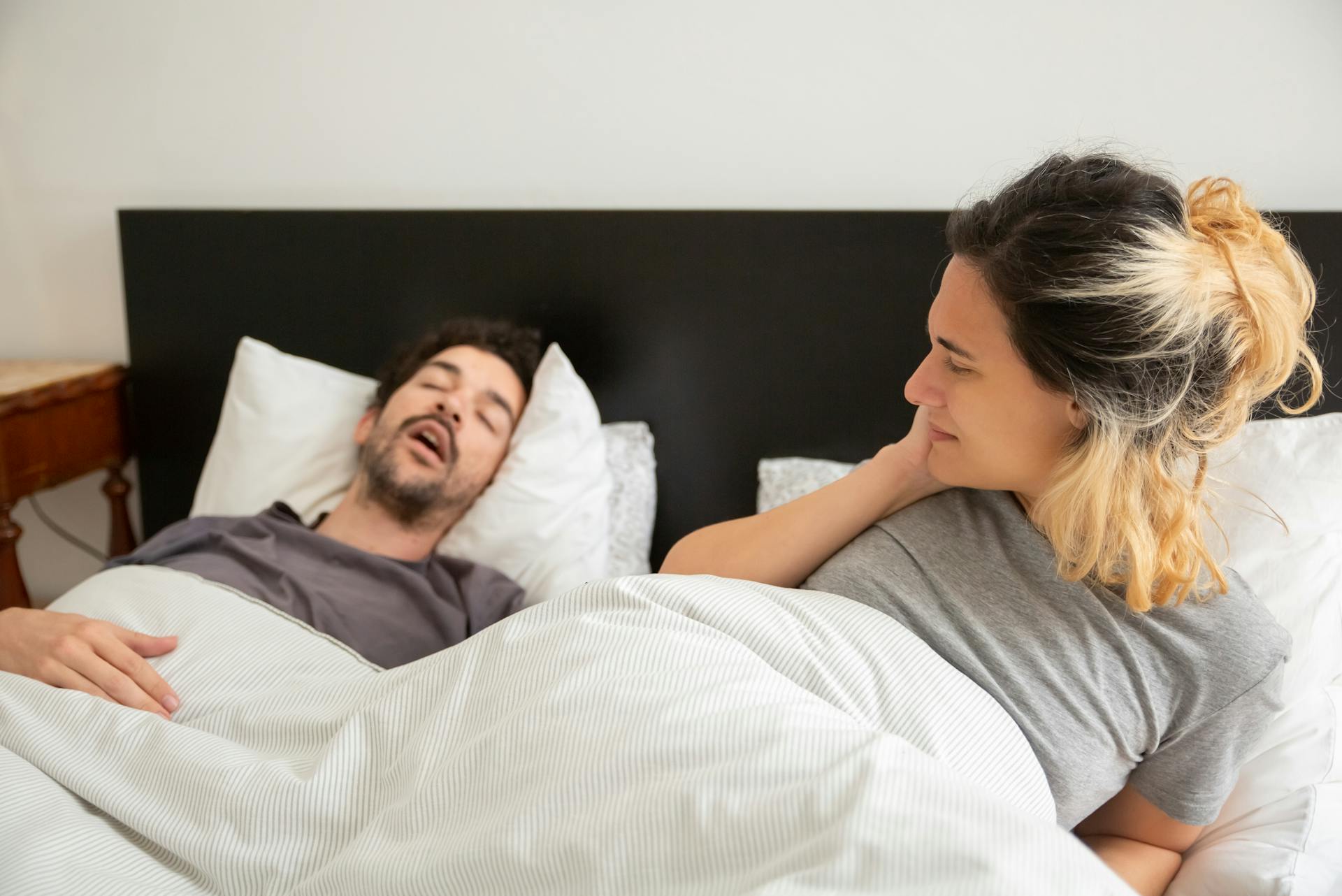 Une femme qui regarde l'homme qui dort à côté d'elle | Source : Pexels