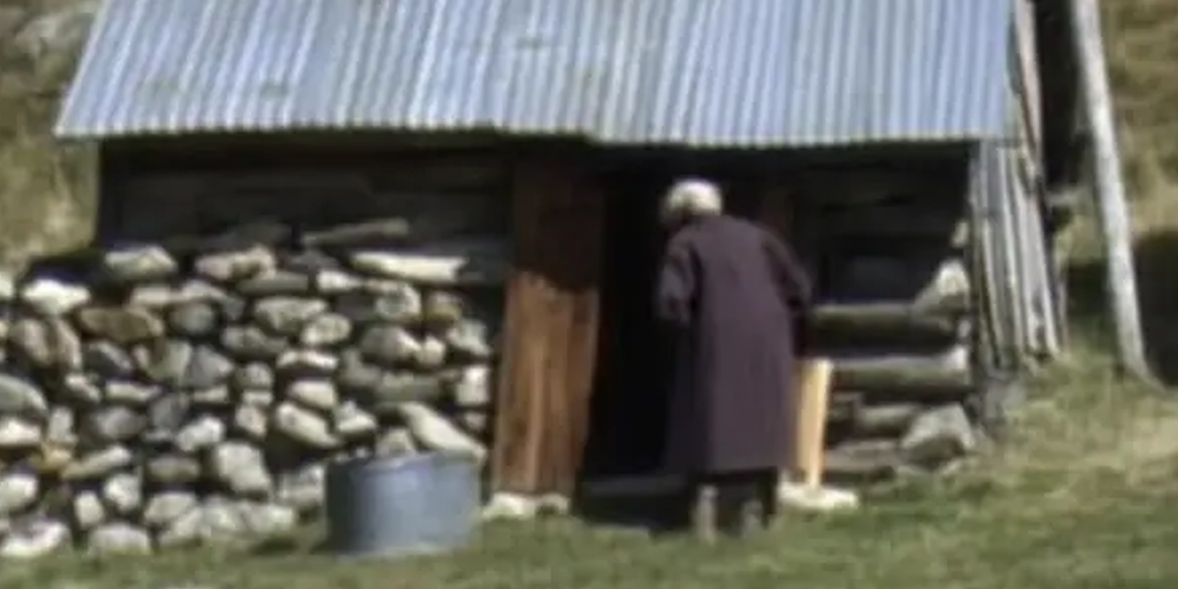 Une vieille femme debout devant un hangar | Source : AmoMama