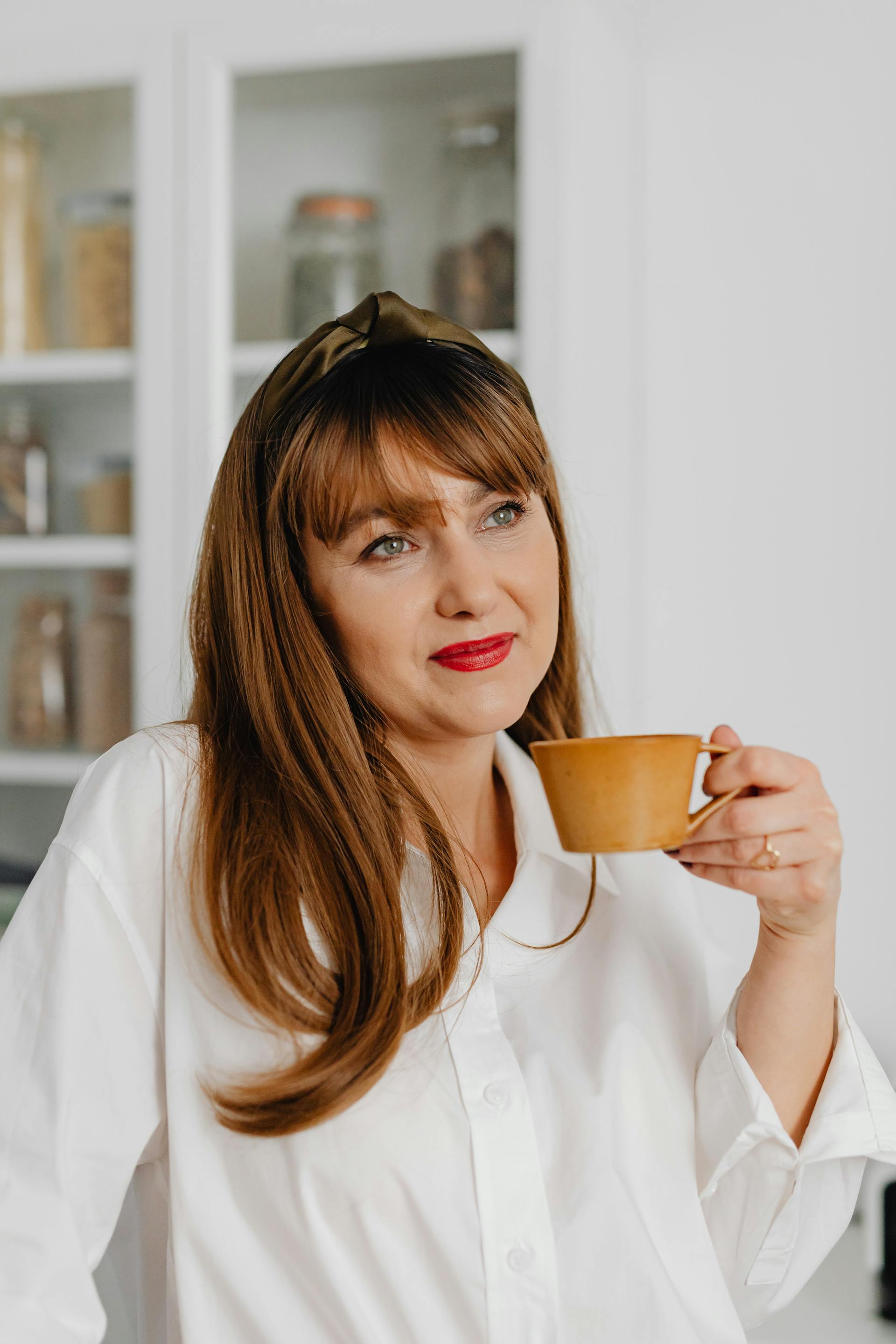 Une femme joyeuse tenant une tasse en céramique | Source : Pexels