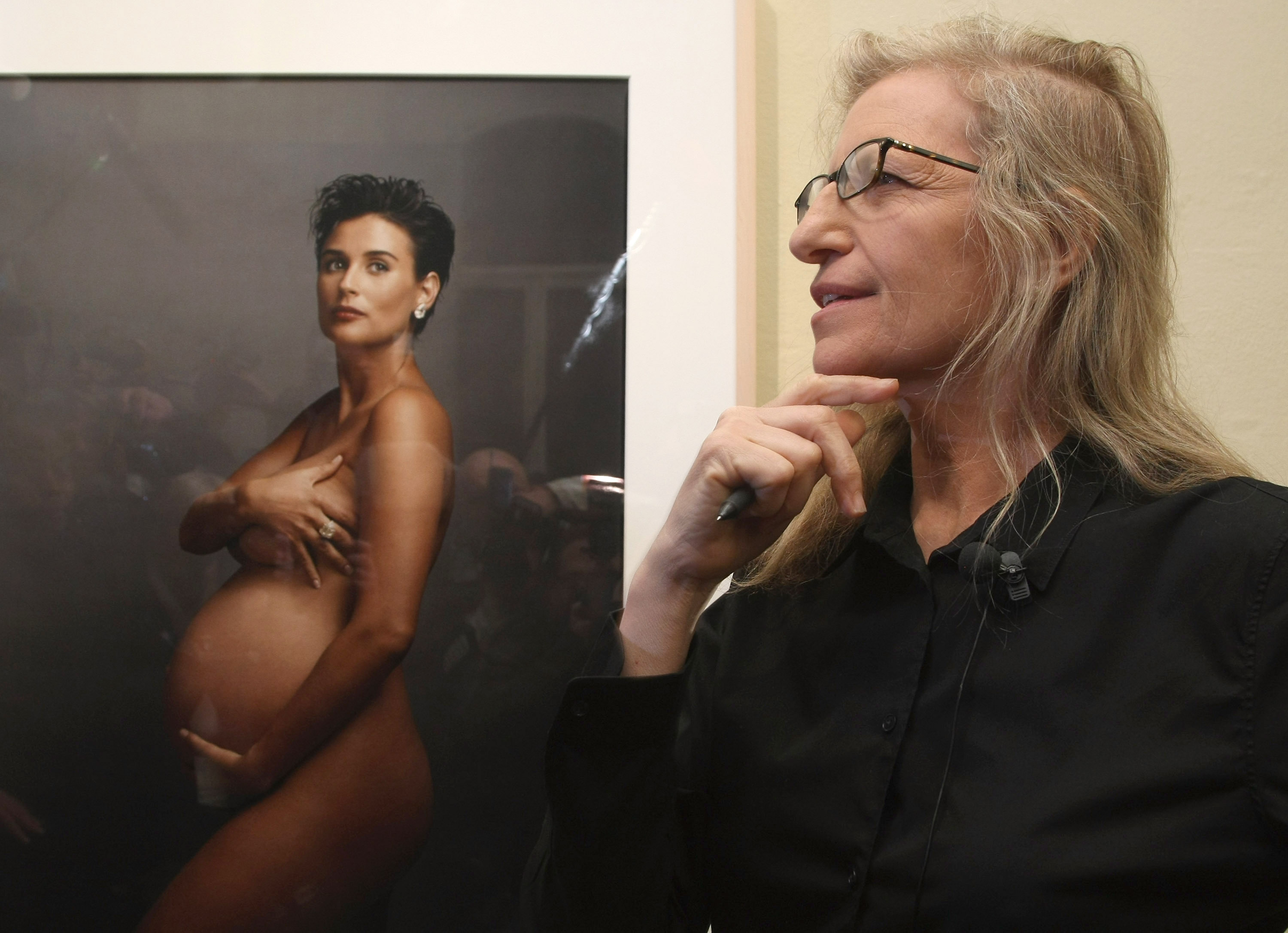 Annie Leibovitz se tient devant un portrait de l'actrice Demi Moore enceinte lors d'une visite de l'exposition "Annie Leibovitz - A Photographer's Life 1990-2005" à la C/O Gallery le 20 février 2009, à Berlin, en Allemagne. | Source : Getty Images