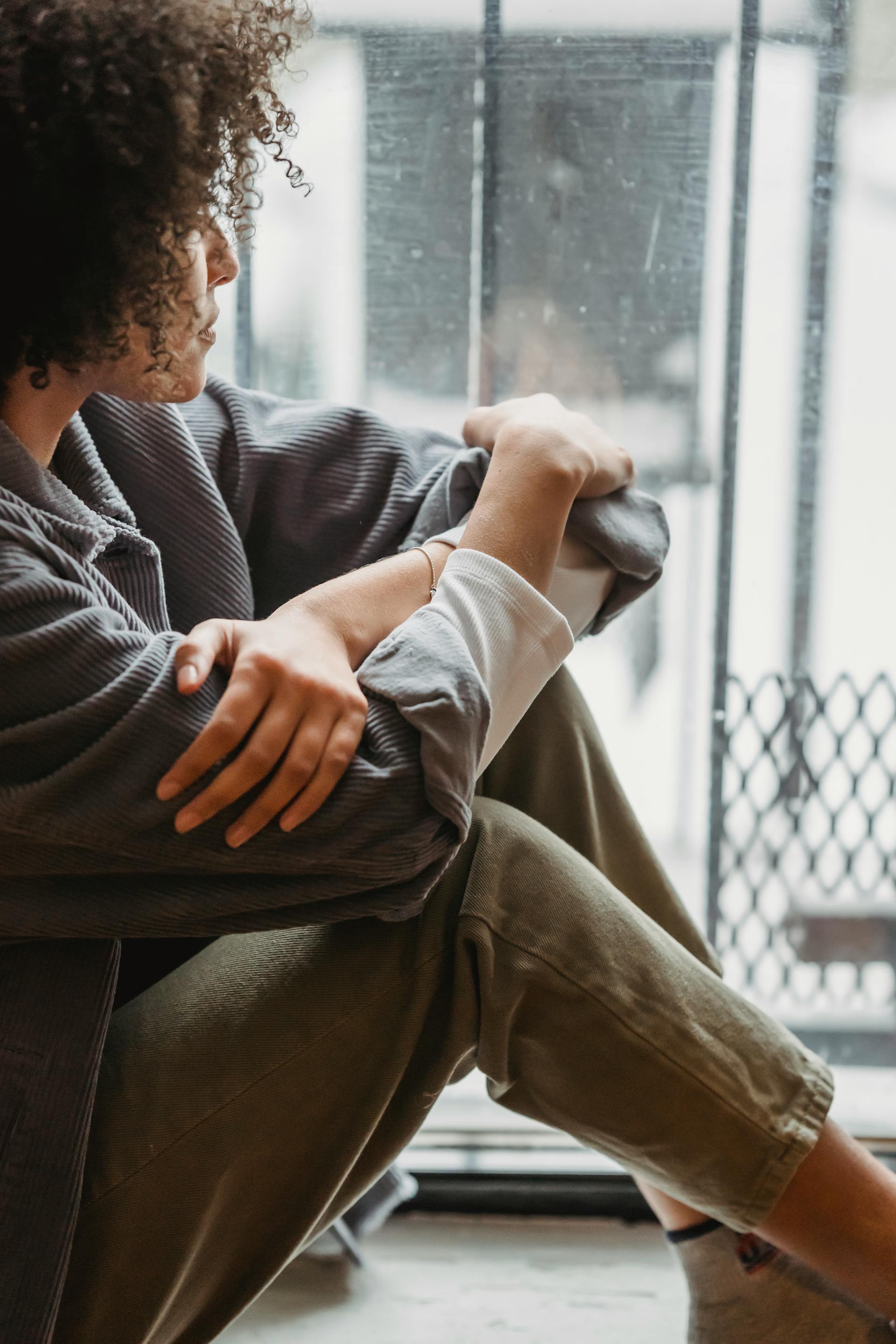 Une femme au cœur brisé assise près de la fenêtre | Source : Pexels