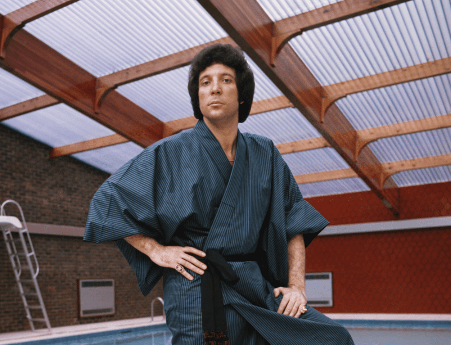 Une image non datée du chanteur gallois et sex-symbol Tom Jones au bord de sa piscine, vêtu d'une robe de chambre, dans sa maison de St Georges Hill, près de Weybridge | Photo : Getty Images