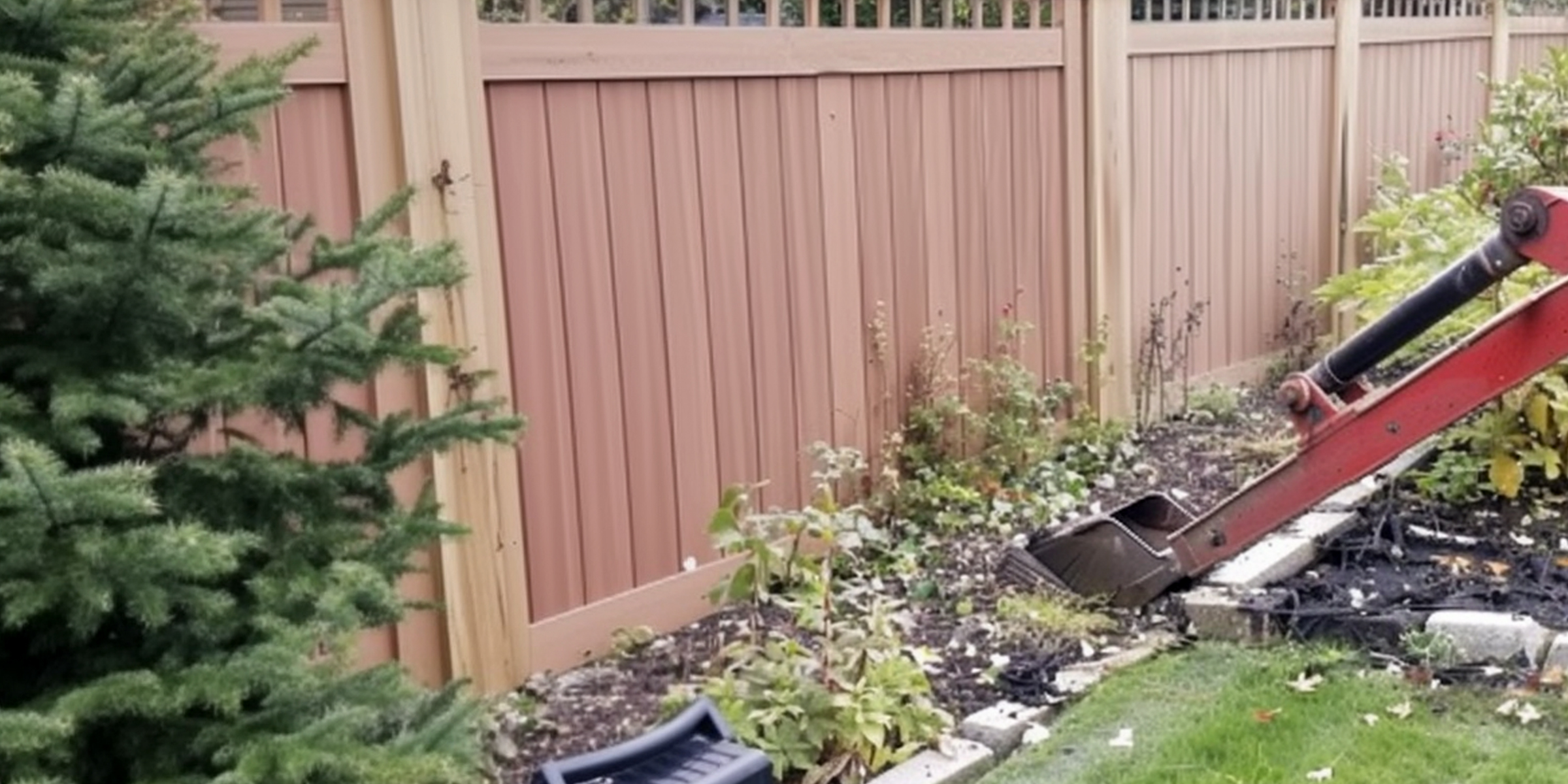 Une machine travaillant sur un jardin près d'une clôture en bois | Source : Amomama